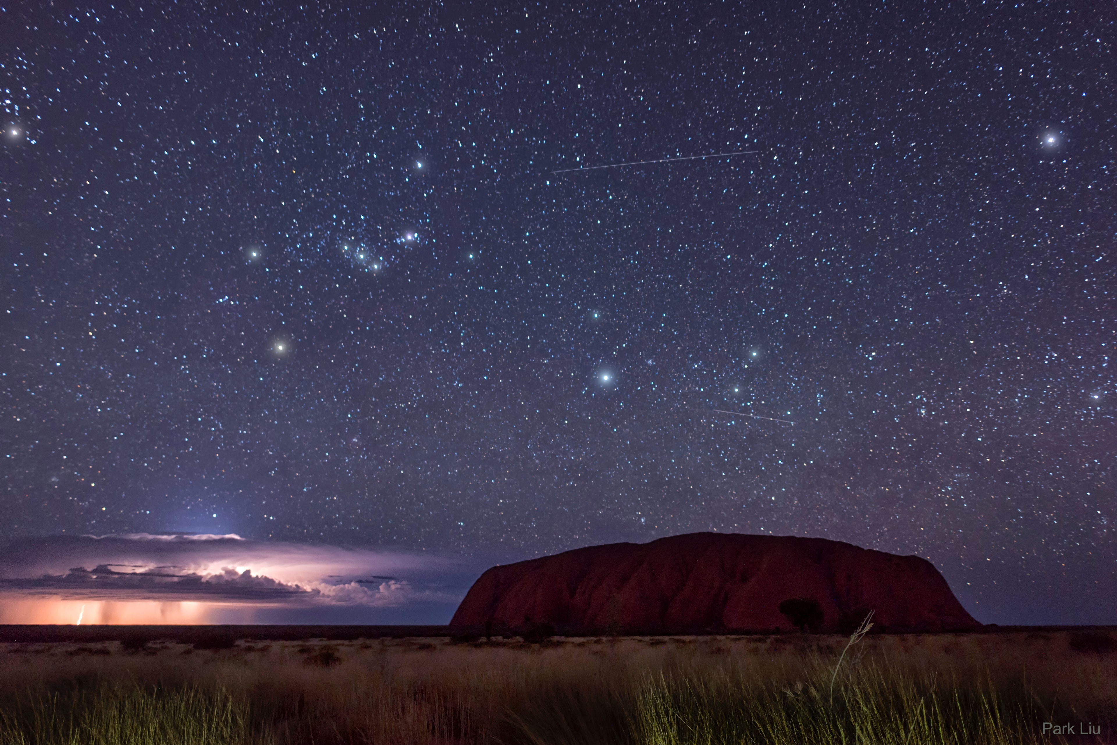 What's happening behind Uluru?  A United Nations World Heritage Site, Uluru  is an extraordinary 350-meter high mountain in central Australia that rises sharply from nearly flat surroundings. Composed of sandstone, Uluru has slowly formed over the past 300 million years as softer rock eroded away.  In the background of the featured image taken in mid-May, a raging thunderstorm is visible.  Far behind both Uluru and the thunderstorm is a star-filled sky highlighted by the constellation of Orion. The Uluru region has been a home to humans for over 22,000 years. Local indigenous people have long noted that when the stars that compose the modern constellation of Orion first appear in the night sky, a hot season involving lightning storms will soon be arriving.