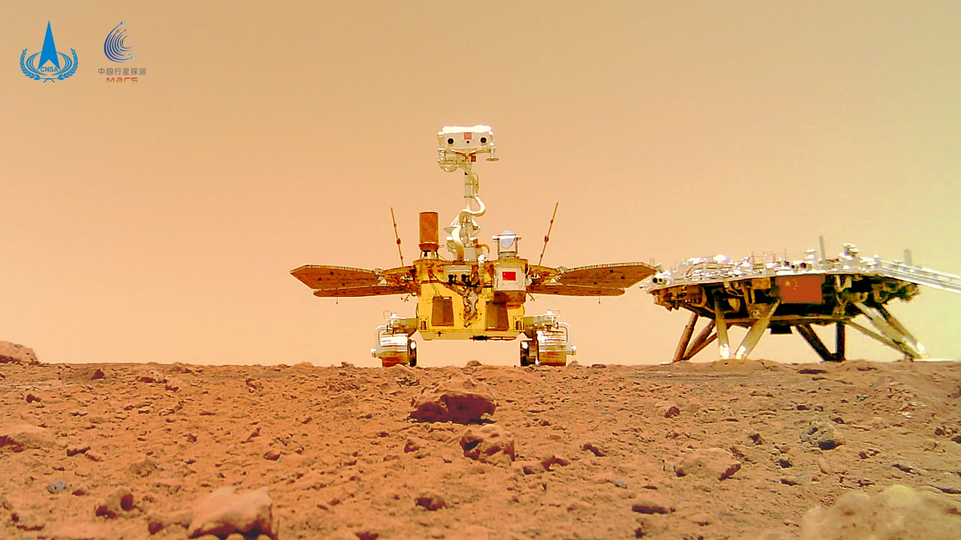 There's a new rover on Mars. In mid-May, China's Tianwen-1 mission delivered the Zhurong rover onto the red planet.  As Mars means Planet of Fire in Chinese, the Zhurong rover's name means, roughly, God of Fire in Chinese mythology.  Zhurong landed in northern Utopia Planitia, the largest known impact basin in the Solar System, and an area reported to have much underground ice. Among many other scientific instruments, Zhurong carries ground-penetrating radar that can detect ice buried even 100-meters deep. Car-sized Zhurong is pictured here next to its landing base.  The image was snapped by a remote camera deployed by the rolling rover. Zhurong's planned 90-day mission includes studying the geology, soil, and atmosphere of Mars in Utopia Planitia.