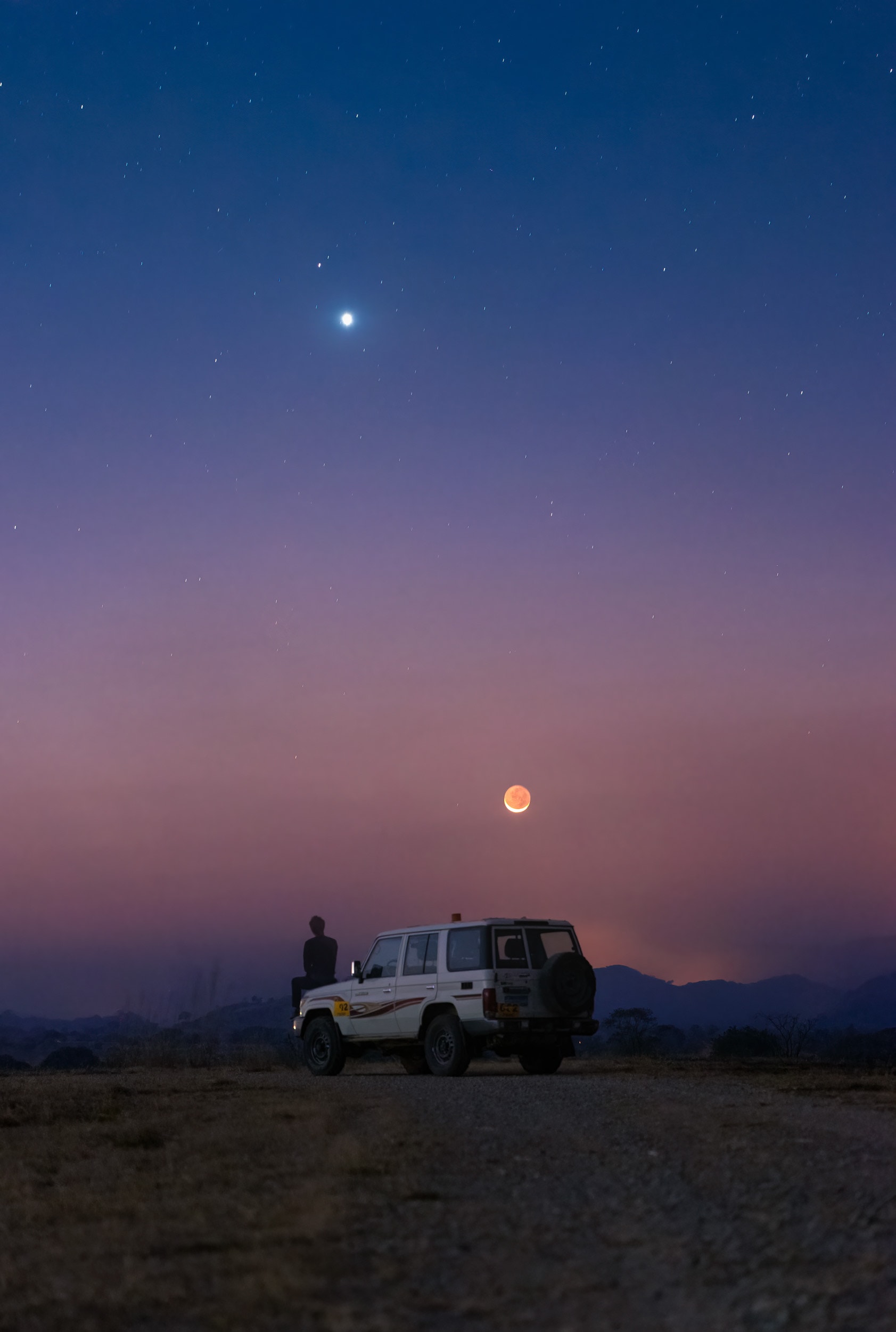 Venus, named for the Roman goddess of love, and Mars, the war god's namesake, come together by moonlight in this serene skyview, recorded on July 11 from Lualaba province, Democratic Republic of Congo, planet Earth. Taken in the western twilight sky shortly after sunset the exposure also records earthshine illuminating the otherwise dark surface of the young crescent Moon. Of course the Moon has moved on. Venus still shines in the west though as the evening star, third brightest object in Earth's sky, after the Sun and the Moon itself. Seen here above a brilliant Venus, Mars moved even closer to the brighter planet and by July 13 could be seen only about a Moon's width away. Mars has since slowly wandered away from much brighter Venus in the twilight, but both are sliding toward bright star Regulus. Alpha star of the constellation Leo, Regulus lies off the top of this frame and anticipates a visit from Venus and then Mars in twilight skies of the coming days.
