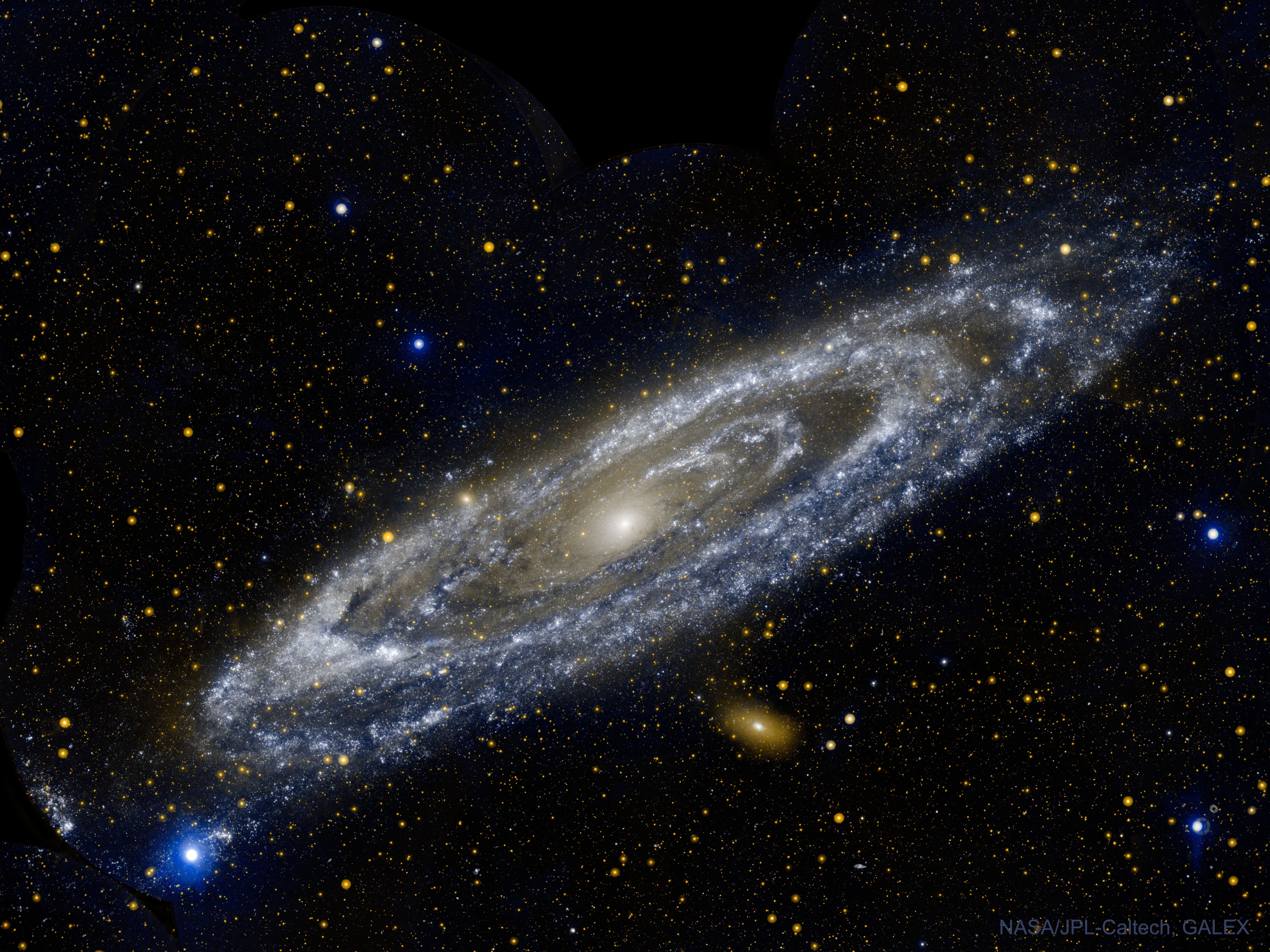 What does the Andromeda galaxy look like in ultraviolet light? Young blue stars circling the galactic center dominate.  A mere 2.5 million light-years away, the Andromeda Galaxy, also known as M31, really is just next door as large galaxies go. Spanning about 230,000 light-years, it took 11 different image fields from NASA's Galaxy Evolution Explorer (GALEX) satellite telescope to produce this gorgeous portrait of the spiral galaxy in ultraviolet light in 2003. While its spiral arms stand out in visible light images, Andromeda's arms look more like rings in ultraviolet. The rings are sites of intense star formation and have been interpreted as evidence that Andromeda collided with its smaller neighboring elliptical galaxy M32 more than 200 million years ago. The Andromeda galaxy and our own comparable Milky Way galaxy are the most massive members of the Local Group of galaxies and are projected to collide in several billion years -- perhaps around the time that our Sun's atmosphere will expand to engulf the Earth.