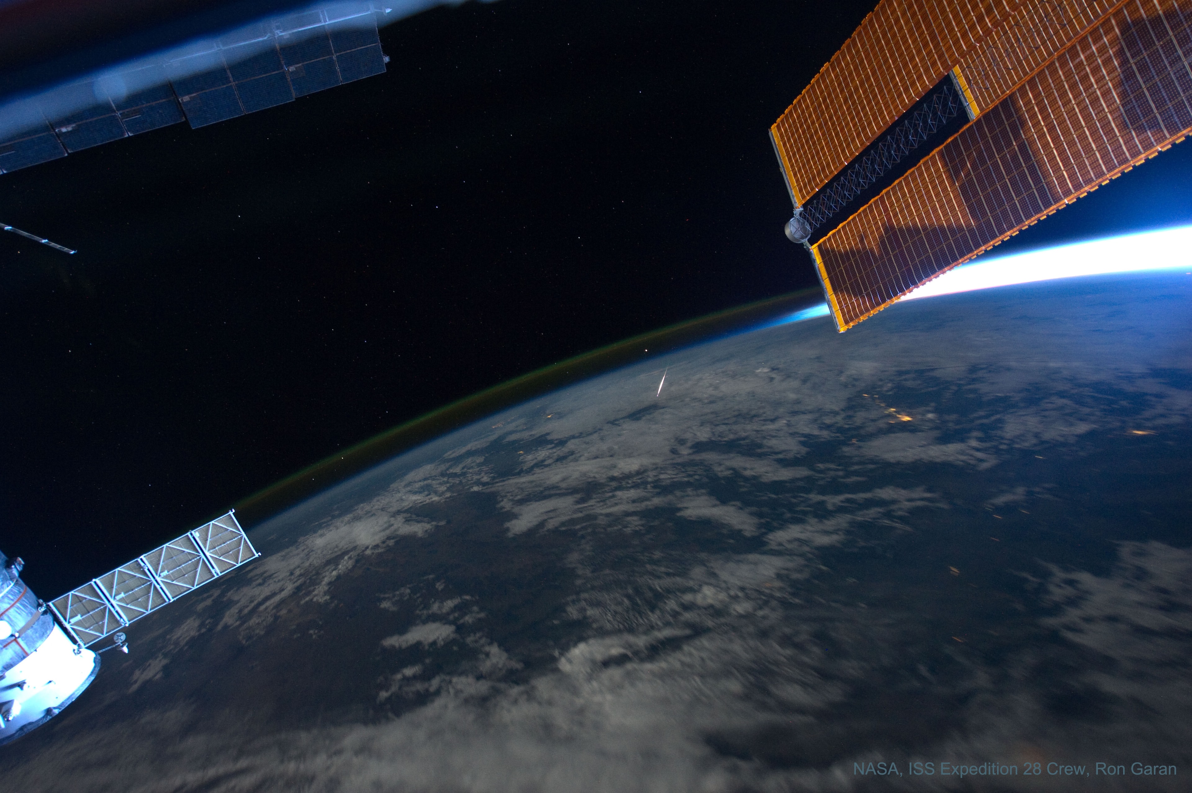 rthlings typically watch meteor showers by looking up. But this remarkable view, captured on August 13, 2011 by astronaut Ron Garan, caught a Perseid meteor by looking down. From Garan's perspective onboard the International Space Station orbiting at an altitude of about 380 kilometers, the Perseid meteors streak below, swept up dust left from comet Swift-Tuttle heated to incandescence. The glowing comet dust grains are traveling at about 60 kilometers per second through the denser atmosphere around 100 kilometers above Earth's surface. In this case, the foreshortened meteor flash is right of frame center, below the curving limb of the Earth and a layer of greenish airglow, just below bright star Arcturus. Want to look up at a meteor shower?  You're in luck, as the 2021 Perseids meteor shower peaks this week. This year, even relatively faint meteors should be visible through clear skies from a dark location as the bright Moon will mostly absent.   Notable Perseids Submissions to APOD: 2018, 2019, 2020