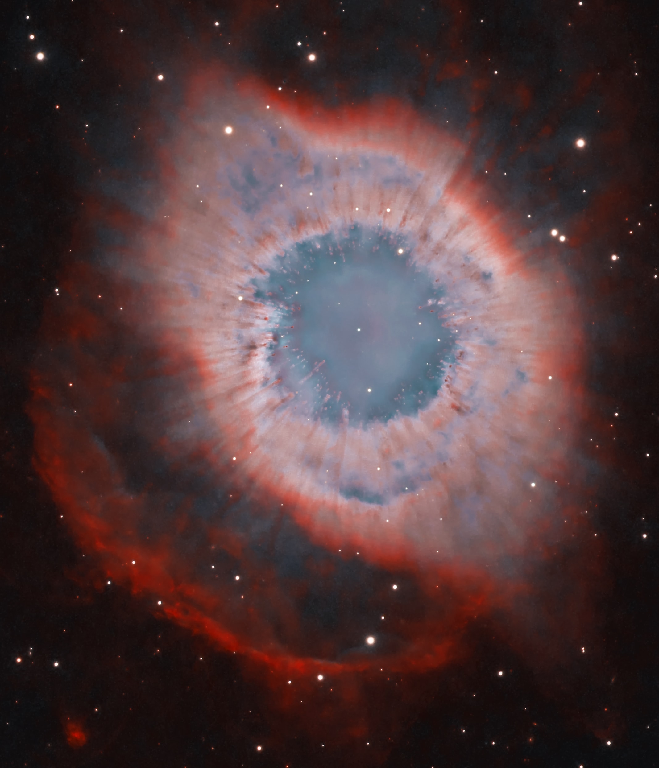 A mere seven hundred light years from Earth, toward the constellation Aquarius, a sun-like star is dying. Its last few thousand years have produced the Helix Nebula (NGC 7293), a well studied and nearby example of a Planetary Nebula, typical of this final phase of stellar evolution.  A total of 90 hours of exposure time have gone in to creating this expansive view of the nebula. Combining narrow band image data from emission lines of hydrogen atoms in red and oxygen atoms in blue-green hues, it shows remarkable details of the Helix's brighter inner region about 3 light-years across. The white dot at the Helix's center is this Planetary Nebula's hot, central star. A simple looking nebula at first glance, the Helix is now understood to have a surprisingly complex geometry.