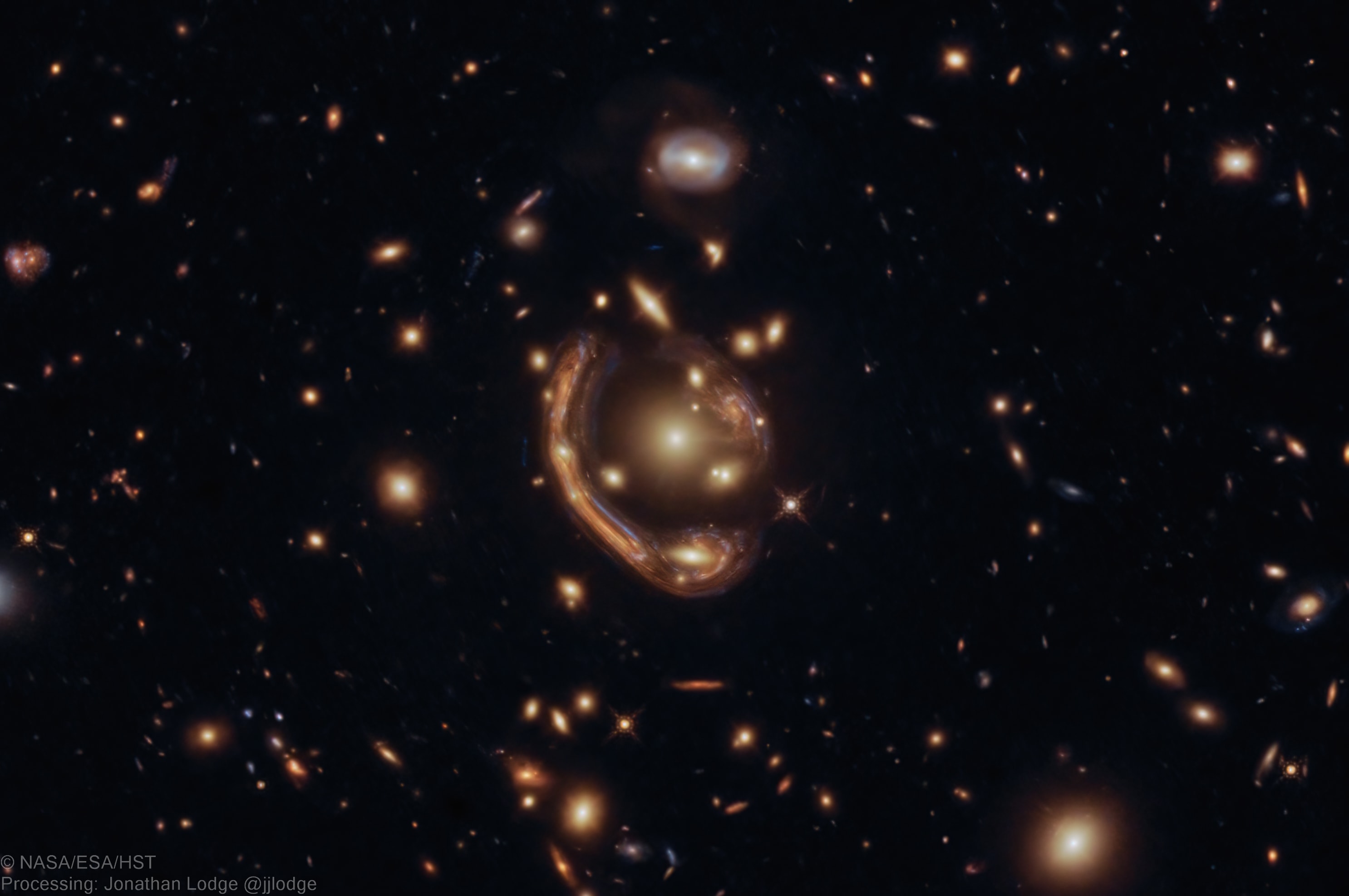 It is difficult to hide a galaxy behind a cluster of galaxies.  The closer cluster's gravity will act like a huge lens, pulling images of the distant galaxy around the sides and greatly distorting them.  This is just the case observed in the featured image recently re-processed image from the Hubble Space Telescope.  The cluster GAL-CLUS-022058c is composed of many galaxies and is  lensing the image of a yellow-red background galaxy into arcs seen around the image center.  Dubbed a molten Einstein ring for its unusual shape, four images of the same background galaxy have been identified. Typically, a foreground galaxy cluster can only create such smooth arcs if most of its mass is smoothly distributed -- and therefore not concentrated in the cluster galaxies visible.  Analyzing the positions of these gravitational arcs gives astronomers a method to estimate the dark matter distribution in galaxy clusters, as well as infer when the stars in these early galaxies began to form.   New APOD Social Mirrors in Arabic: On Facebook, Instagram, and Twitter
