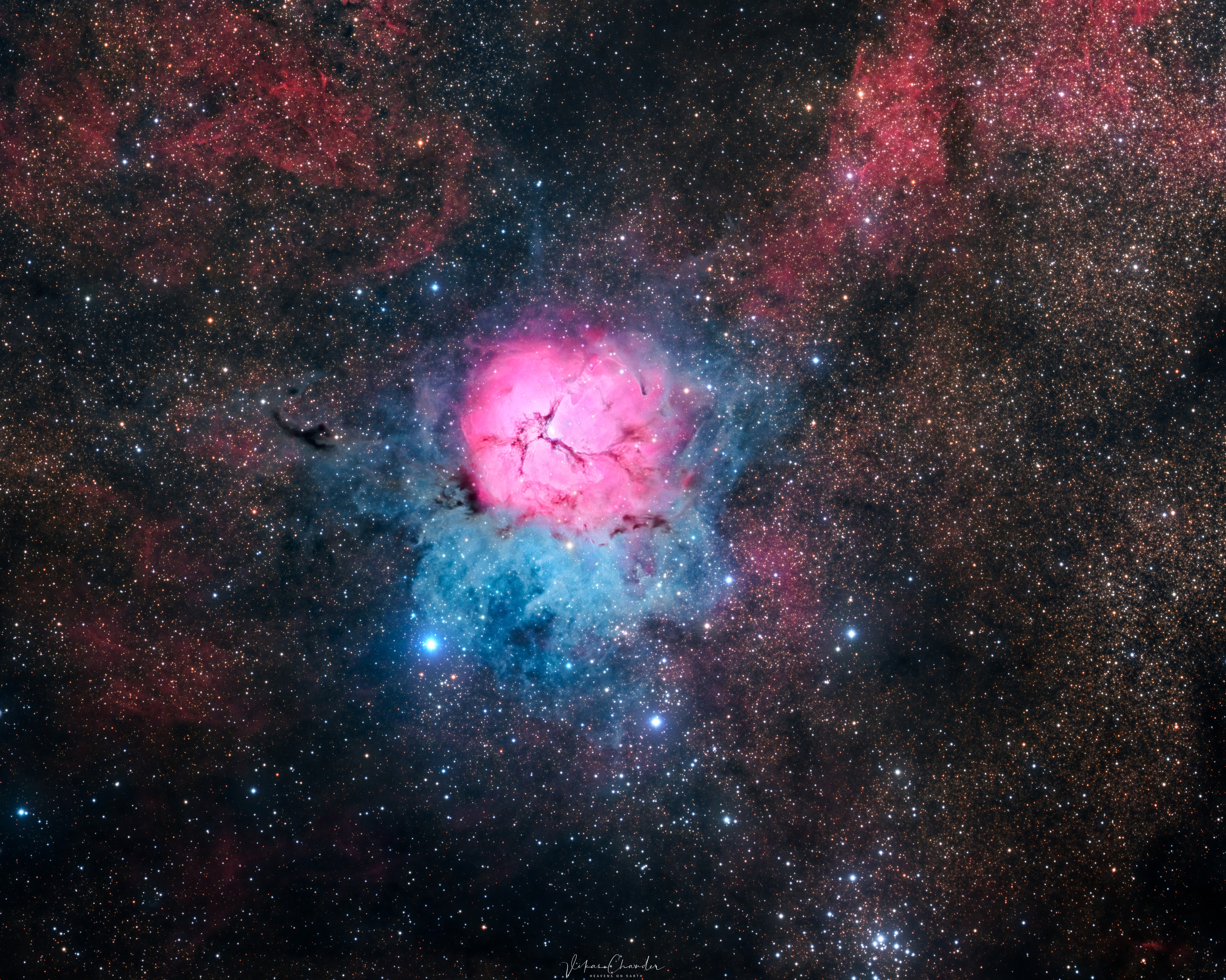 The beautiful Trifid Nebula is a cosmic study in contrasts. Also known as M20, it lies about 5,000 light-years away toward the nebula rich constellation Sagittarius. A star forming region in the plane of our galaxy, the Trifid does illustrate three different types of astronomical nebulae; red emission nebulae dominated by light from hydrogen atoms, blue reflection nebulae produced by dust reflecting starlight, and dark nebulae where dense dust clouds appear in silhouette. But the red emission region, roughly separated into three parts by obscuring dust lanes, is what lends the Trifid its popular name. Pillars and jets sculpted by newborn stars, above and right of the emission nebula's center, appear in famous Hubble Space Telescope close-up images of the region. The Trifid Nebula is about 40 light-years across. Too faint to be seen by the unaided eye, it almost covers the area of a full moon in planet Earth's sky. Open star cluster M21 just peeks into this telescopic field of view along the bottom right edge of the frame.