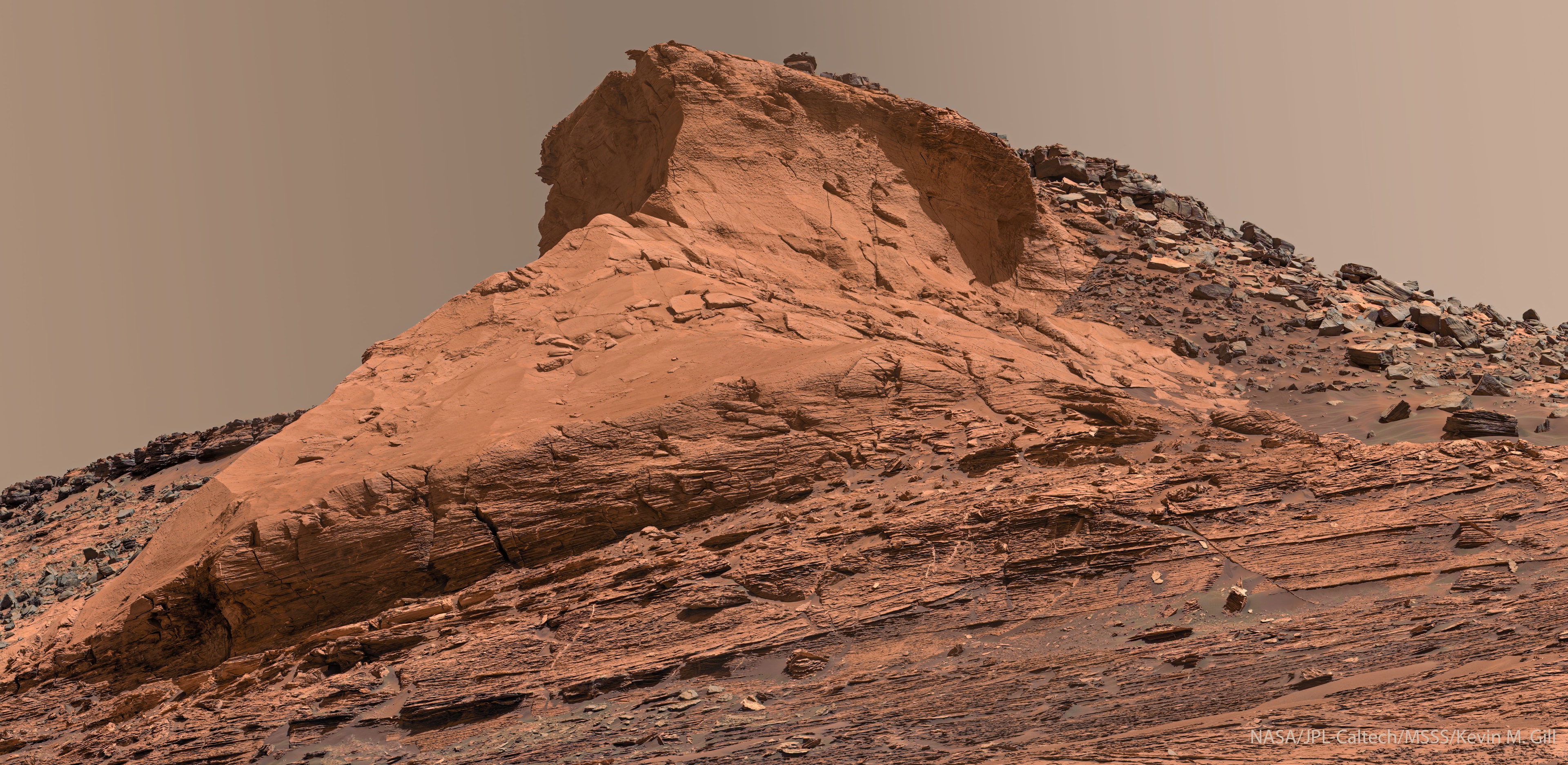 What created this unusual hill on Mars? No one is sure.  A good outlook to survey the surrounding area, Siccar Point stands out from its surroundings in Gale Crater. The unusual mound was visited by the robotic Curiosity rover exploring Mars late last year. Siccar Point not only has a distinctive shape, it has dark rocks above lighter rocks.  The apparent much younger age of the dark rocks indicates a time-break in the usual geological ordering of rock layers -- by a process yet unknown. The Martian hill is named for Siccar Point on Earth, a place in Scotland itself distinctive as a junction between two different rock layers.  Curiosity continues to explore Gale crater on Mars, looking for clues of ancient life. Simultaneously, 2300 kilometers away, its sister rover Perseverance explores Jezero crater, there assisted by the flight-capable scout Ingenuity.