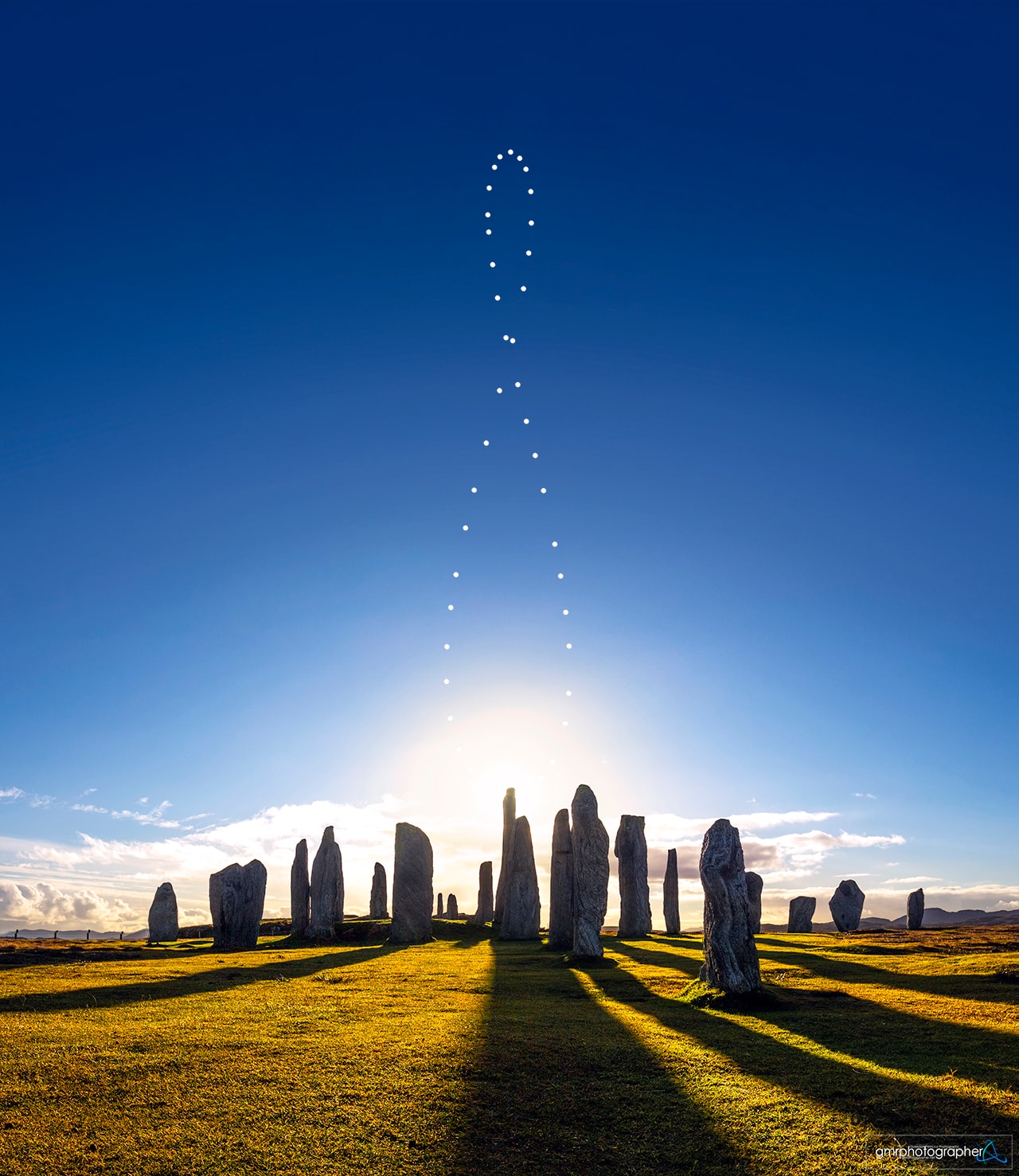 If you went outside at the same time every day and took a picture that included the Sun, how would the Sun's position change?  A more visual answer to that question is an analemma, a composite image taken from the same spot at the same time over the course of a year.  The featured analemma was composed from images taken every few days at noon near the village of Callanish in the Outer Hebrides in Scotland, UK.  In the foreground are the Callanish Stones, a stone circle built around 2700 BC during humanity's Bronze Age.  It is not known if the placement of the Callanish Stones has or had astronomical significance.  The ultimate causes for the figure-8 shape of this and all analemmas are the tilt of the Earth axis and the ellipticity of the Earth's orbit around the Sun.  At the solstices, the Sun will appear at the top or bottom of an analemma. The featured image was taken near the December solstice and so the Sun appears near the bottom.  Equinoxes, however, correspond to analemma middle points -- not the intersection point. This coming Friday at 1:04 am (UT) -- Thursday in the Americas -- is the equinox ("equal night"), when day and night are equal over all of planet Earth. Many cultures celebrate a change of season at an equinox.   Explore Your Universe: Random APOD Generator