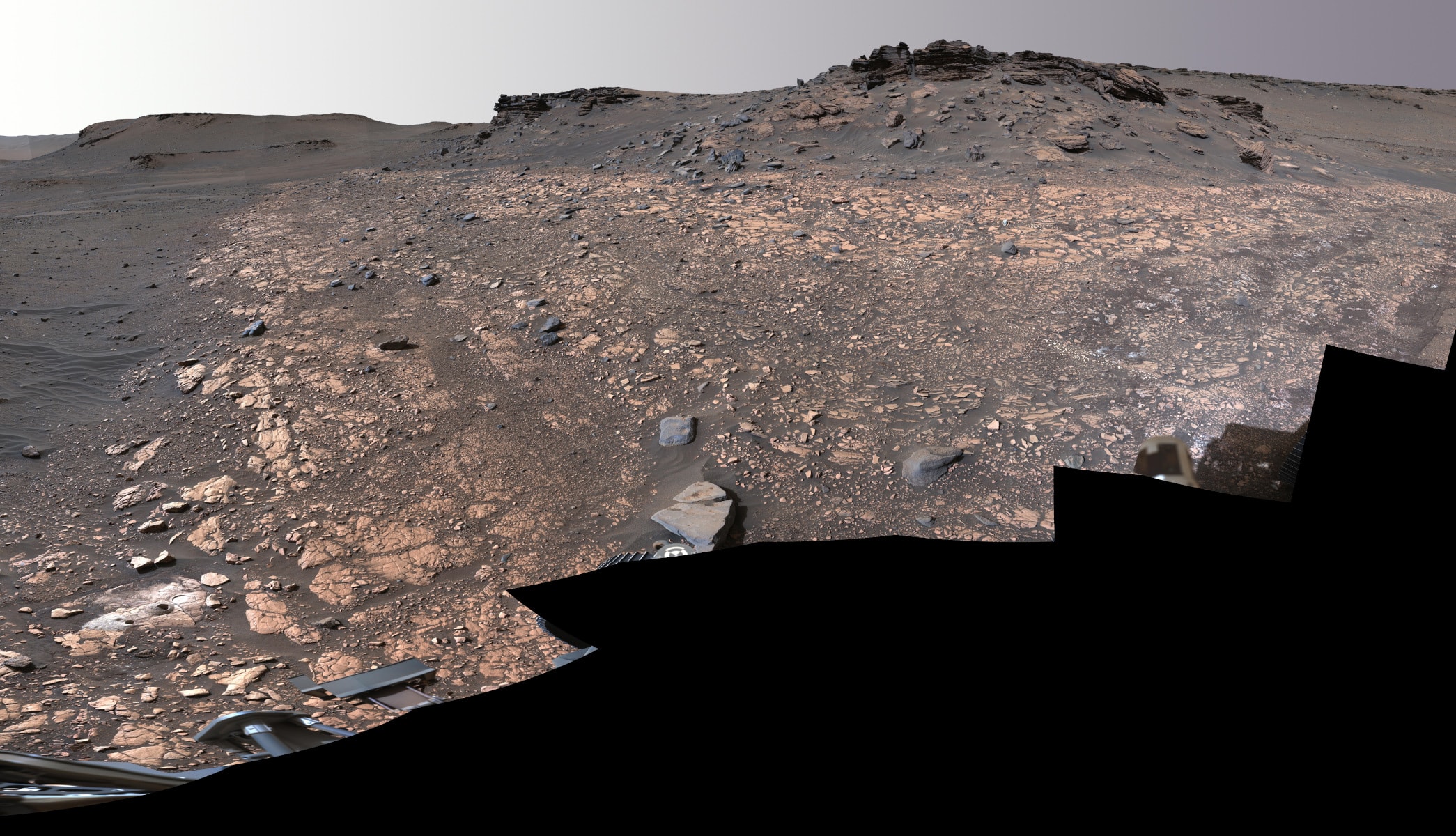 The Perseverance rover's Mastcam-Z captured images to create this mosaic on August 4, 2022. The car-sized robot was continuing its exploration of the fan-shaped delta of a river that, billions of years ago, flowed into Jezero Crater on Mars. Sedimentary rocks preserved in Jezero's delta are considered one of the best places on Mars to search for potential signs of ancient microbial life and sites recently sampled by the rover, dubbed Wildcat Ridge and Skinner Ridge, are at lower left and upper right in the frame. The samples taken from these areas were sealed inside ultra-clean sample tubes, ultimately intended for return to Earth by future missions. Starting with the Pathfinder Mission and Mars Global Surveyor in 1997, the last 25 years of a continuous robotic exploration of the Red Planet has included orbiters, landers, rovers, and a helicopter from planet Earth.