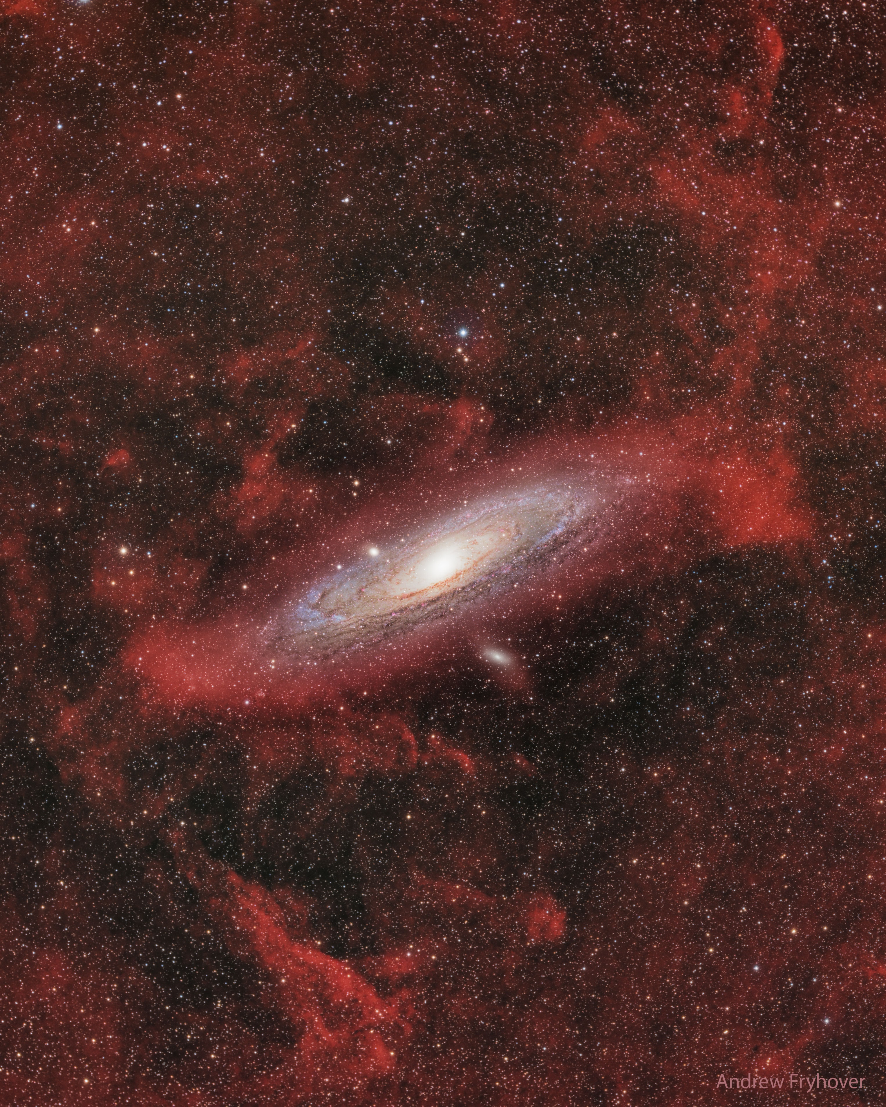 What are those red clouds surrounding the Andromeda galaxy? This galaxy, M31, is often imaged by planet Earth-based astronomers. As the nearest large spiral galaxy, it is a familiar sight with dark dust lanes, bright yellowish core, and spiral arms traced by clouds of bright blue stars.  A mosaic of well-exposed broad and narrow-band image data, this deep portrait of our neighboring island universe offers strikingly unfamiliar features though, faint reddish clouds of glowing ionized hydrogen gas in the same wide field of view. Most of the ionized hydrogen clouds surely lie in the foreground of the scene, well within our Milky Way Galaxy. They are likely associated with the pervasive, dusty interstellar cirrus clouds scattered hundreds of light-years above our own galactic plane. Some of the clouds, however, occur right in the Andromeda galaxy itself, and some in M110, the small galaxy just below.