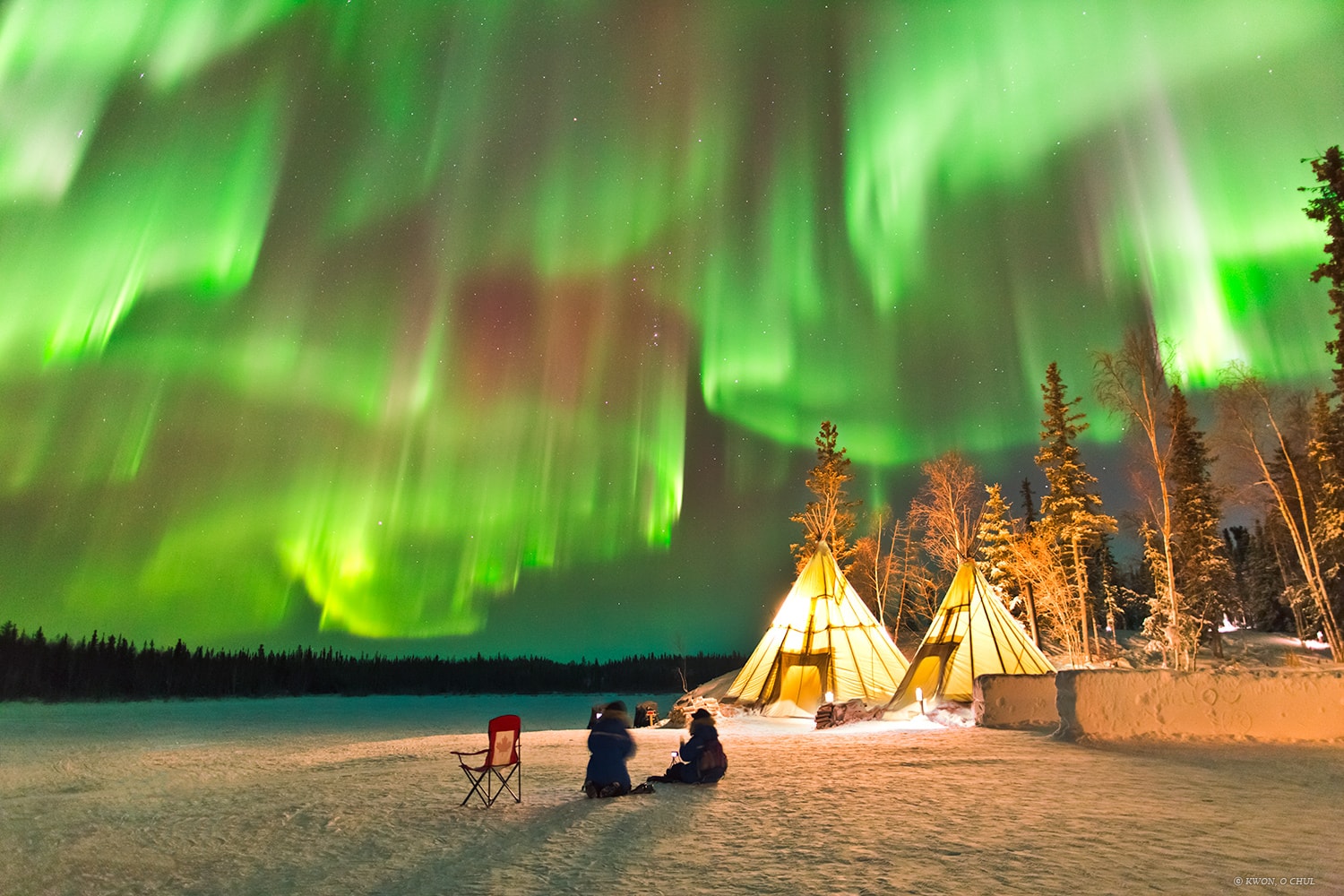 Gusting solar winds and blasts of charged particles from the Sun resulted in several rewarding nights of auroras back in 2014 December, near the peak of the last 11-year solar cycle.  The featured image captured dramatic auroras stretching across a sky near the town of Yellowknife in northern Canada.  The auroras were so bright that they not only inspired awe, but were easily visible on an image exposure of only 1.3 seconds. A video taken concurrently shows the dancing sky lights evolving in real time as tourists, many there just to see auroras, respond with cheers. The conical dwellings on the image right are tipis, while far in the background, near the image center, is the constellation of Orion.  Auroras may increase again over the next few years as our Sun again approaches solar maximum.