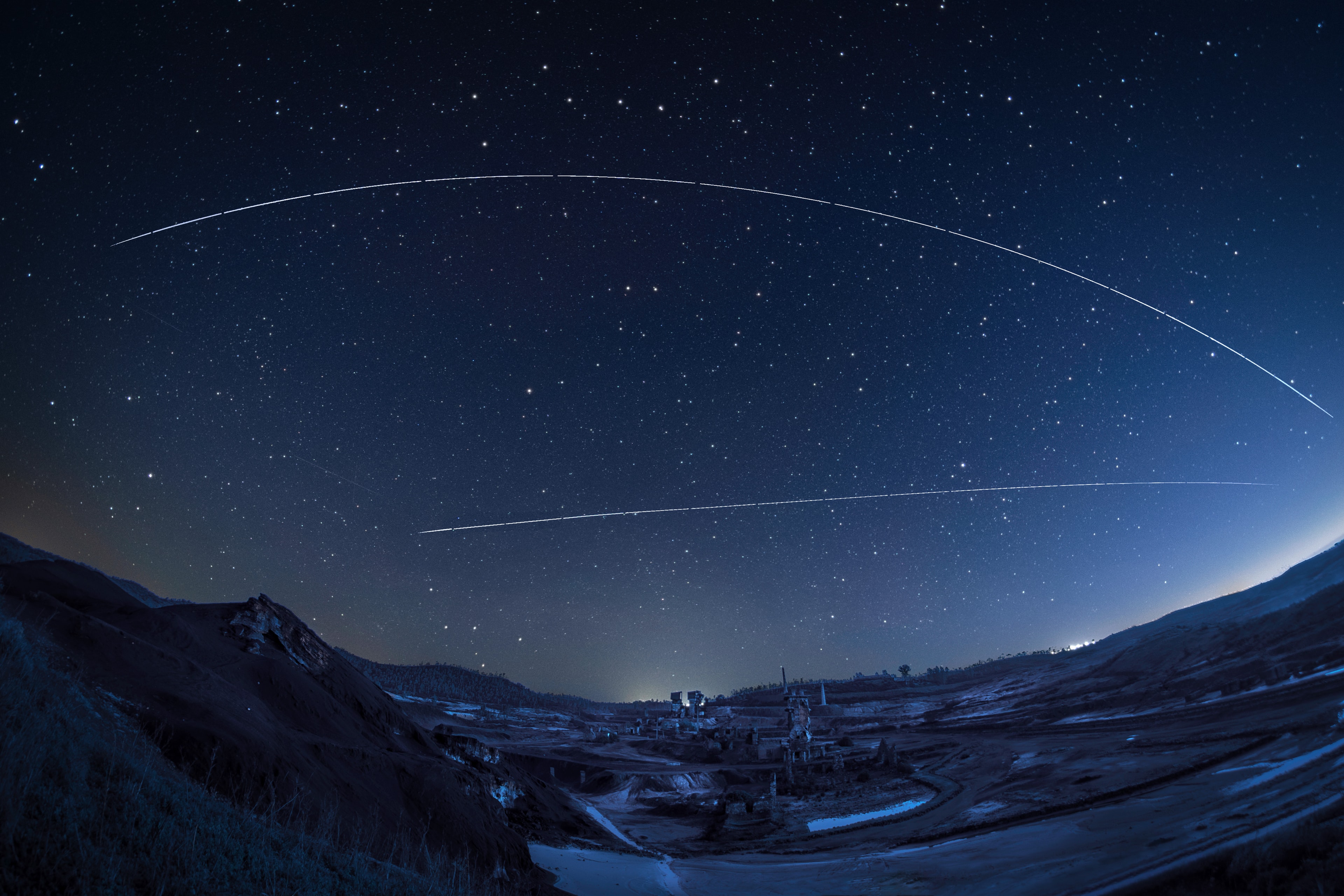 On January 3, two space stations already illuminated by sunlight in low Earth orbit crossed this dark predawn sky. Moving west to east (left to right) across the composited timelapse image China's Tiangong Space Station traced the upper trail captured more than an hour before the local sunrise. Seen against a starry background Tiangong passes just below the inverted Big Dipper asterism of Ursa Major near the peak of its bright arc, and above north pole star Polaris. But less than five minutes before, the International Space Station had traced its own sunlit streak across the dark sky. Its trail begins just above the W-shape outlined by the bright stars of Cassiopeia near the northern horizon. The dramatic foreground spans an abandoned mine at Achada do Gamo in southeastern Portugal.