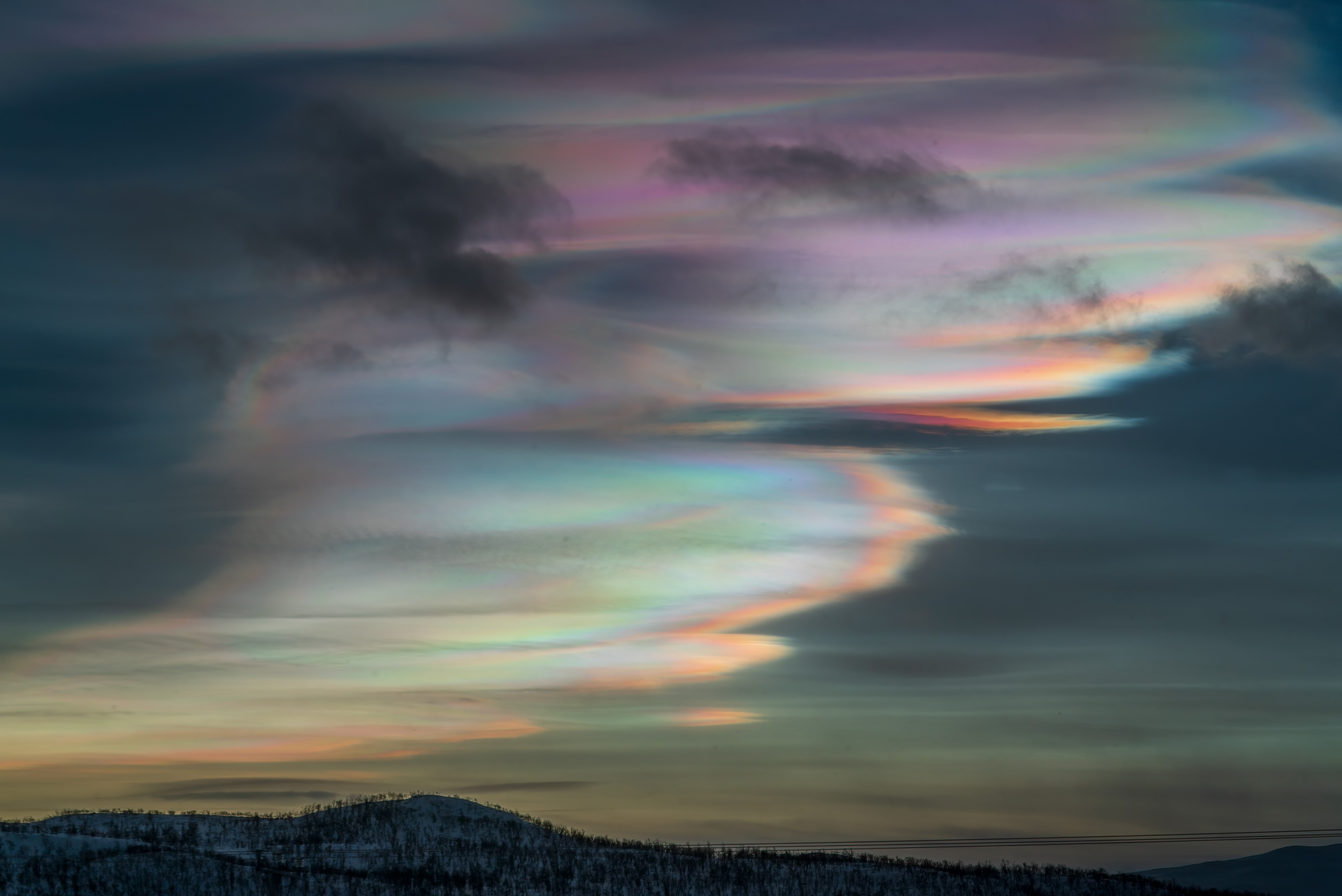 Vivid and lustrous, wafting iridescent waves of color wash across this skyscape from Kilpisjärvi, Finland. Known as nacreous clouds or mother-of-pearl clouds, they are rare. But their unforgettable appearance was captured looking south at 69 degrees north latitude at sunset on January 24.  A type of polar stratospheric cloud, they form when unusually cold temperatures in the usually cloudless lower stratosphere form ice crystals. Still sunlit at altitudes of around 15 to 25 kilometers, the clouds can diffract sunlight even after sunset and just before the dawn.