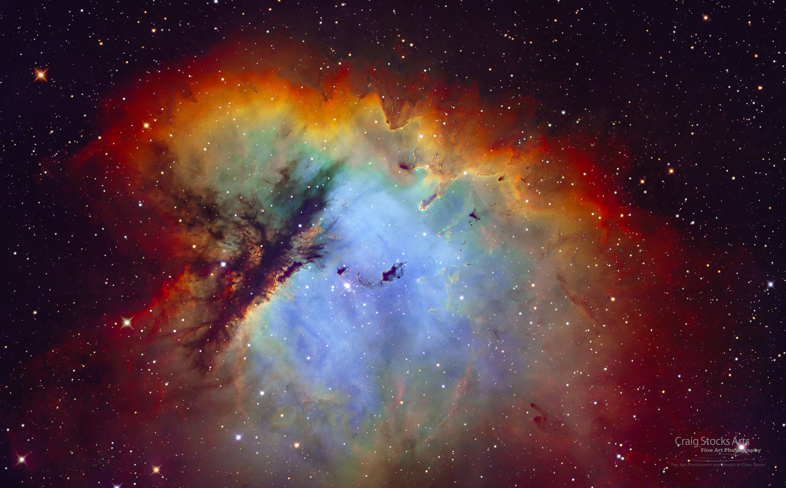 Look through the cosmic cloud cataloged as NGC 281 and you might miss the stars of open cluster IC 1590. Formed within the nebula, that cluster's young, massive stars ultimately power the pervasive nebular glow. The eye-catching shapes looming in the featured portrait of NGC 281 are sculpted dusty columns and dense Bok globules seen in silhouette, eroded by intense, energetic winds and radiation from the hot cluster stars. If they survive long enough, the dusty structures could also be sites of future star formation. Playfully called the Pacman Nebula because of its overall shape, NGC 281 is about 10,000 light-years away in the constellation Cassiopeia. This sharp composite image was made through narrow-band filters. It combines emission from the nebula's hydrogen and oxygen atoms to synthesize red, green, and blue colors. The scene spans well over 80 light-years at the estimated distance of NGC 281.