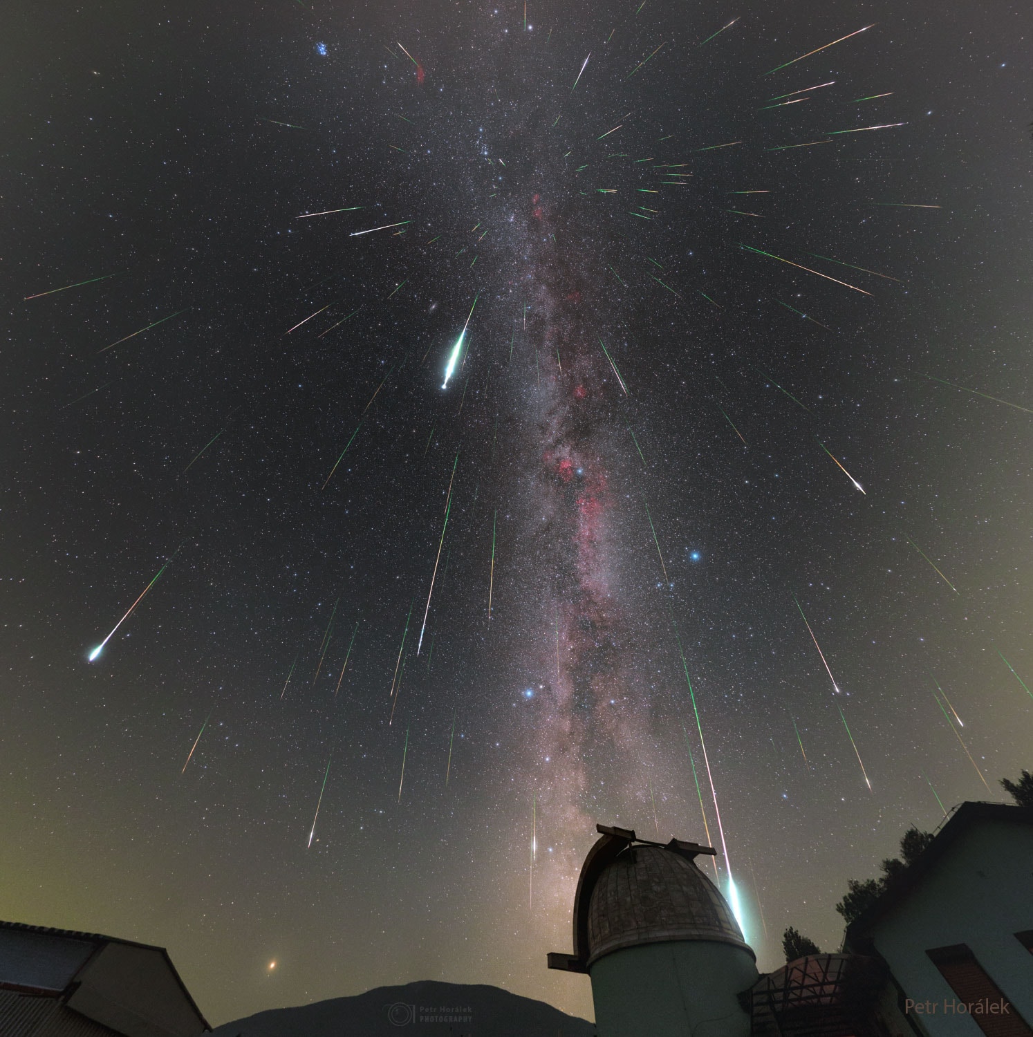 This is a good week to see meteors.  Comet dust will rain down on planet Earth, streaking through dark skies during peak nights of the annual Perseid Meteor Shower.  The featured composite image was taken during the 2018 Perseids from the Poloniny Dark Sky Park in Slovakia.  The dome of the observatory in the foreground is on the grounds of Kolonica Observatory. Although the comet dust particles travel parallel to each other, the resulting shower meteors clearly seem to radiate from a single point on the sky in the eponymous constellation Perseus.  The radiant effect is due to perspective, as the parallel tracks appear to converge at a distance, like train tracks.  The Perseid Meteor Shower is expected to reach its highest peak on Saturday after midnight.  Since a crescent Moon will rise only very late that night, cloudless skies will be darker than usual, making a high number of faint meteors potentially visible this year.