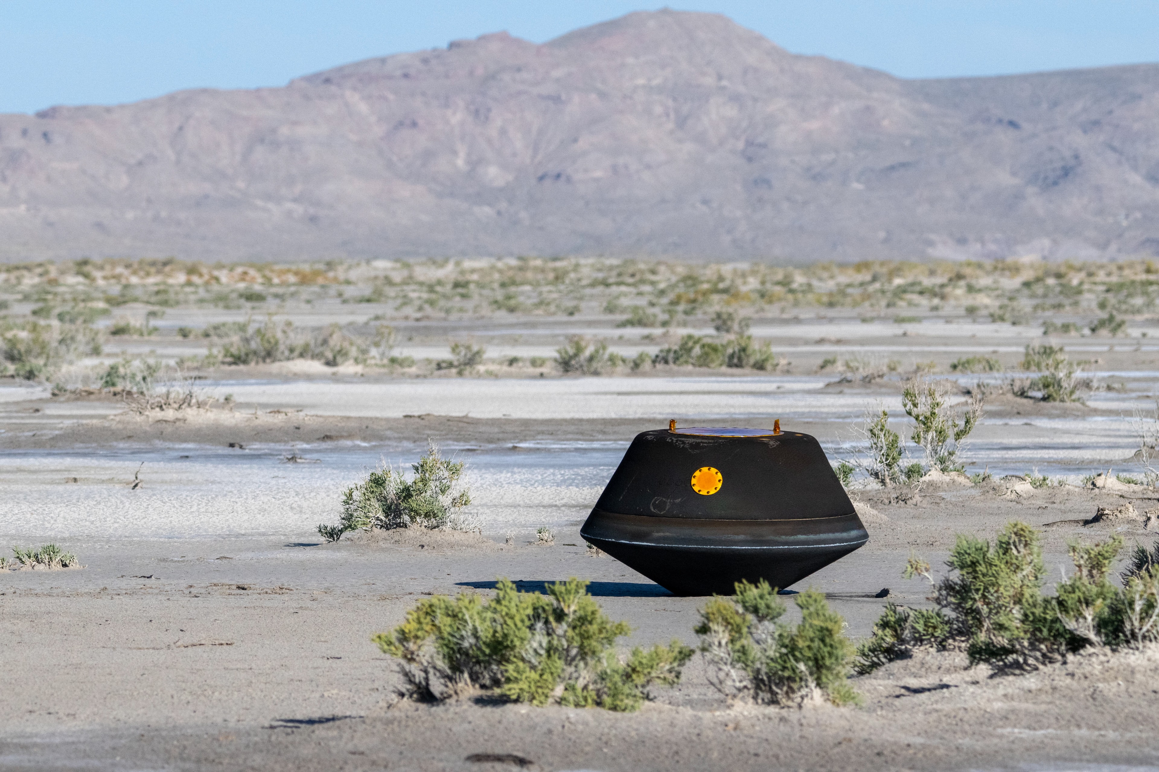 Back from asteroid 101955 Bennu, a 110-pound, 31-inch wide sample return capsule rests in a desert on planet Earth in this photo, taken at the Department of Defense Utah Test and Training Range near Salt Lake City last Sunday, September 24. Dropped off by the OSIRIS-Rex spacecraft, the capsule looks charred from the extreme temperatures experienced during its blistering descent through Earth's dense atmosphere. OSIRIS-Rex began its home-ward journey from Bennu in May of 2021. Delivered to NASA’s Johnson Space Center in Houston on September 25, the capsule's canister is expected to contain an uncontaminated sample of about a half pound (250 grams) of Bennu's loosely packed regolith. Working in a new laboratory designed for the OSIRIS-REx mission, scientists and engineers will complete the canister disassembly process, and plan to unveil the sample of the near-Earth asteroid in a broadcast event on October 11.