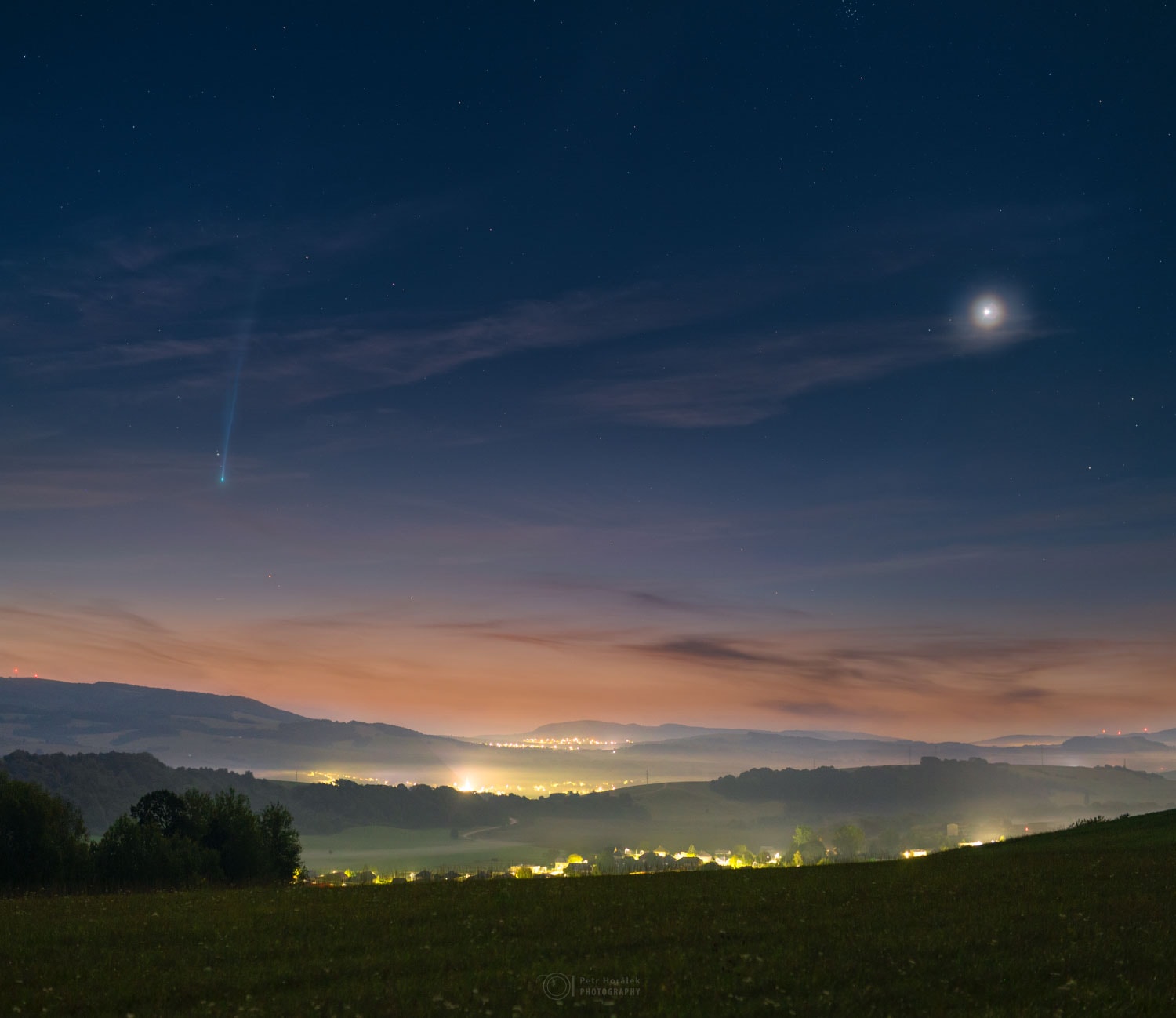 This scene would be beautiful even without the comet. By itself, the sunrise sky is an elegant deep blue on high, with faint white stars peeking through, while near the horizon is a pleasing tan. By itself, the foreground hills of eastern Slovakia are appealingly green, with the Zadňa hura and Veľká hora hills in the distance, and with the lights of small towns along the way.  Venus, by itself on the right, appears unusually exquisite, surrounded by a colorful atmospheric corona. But what attracts the eye most is the comet. On the left, in this composite image taken just before dawn yesterday morning, is Comet Nishimura.  On recent mornings around the globe, its bright coma and long ion tail make many a morning panoramic photo unusually beautiful.  Tomorrow, C/2023 P1 (Nishimura) will pass its nearest to the Earth for about the next 434 years.