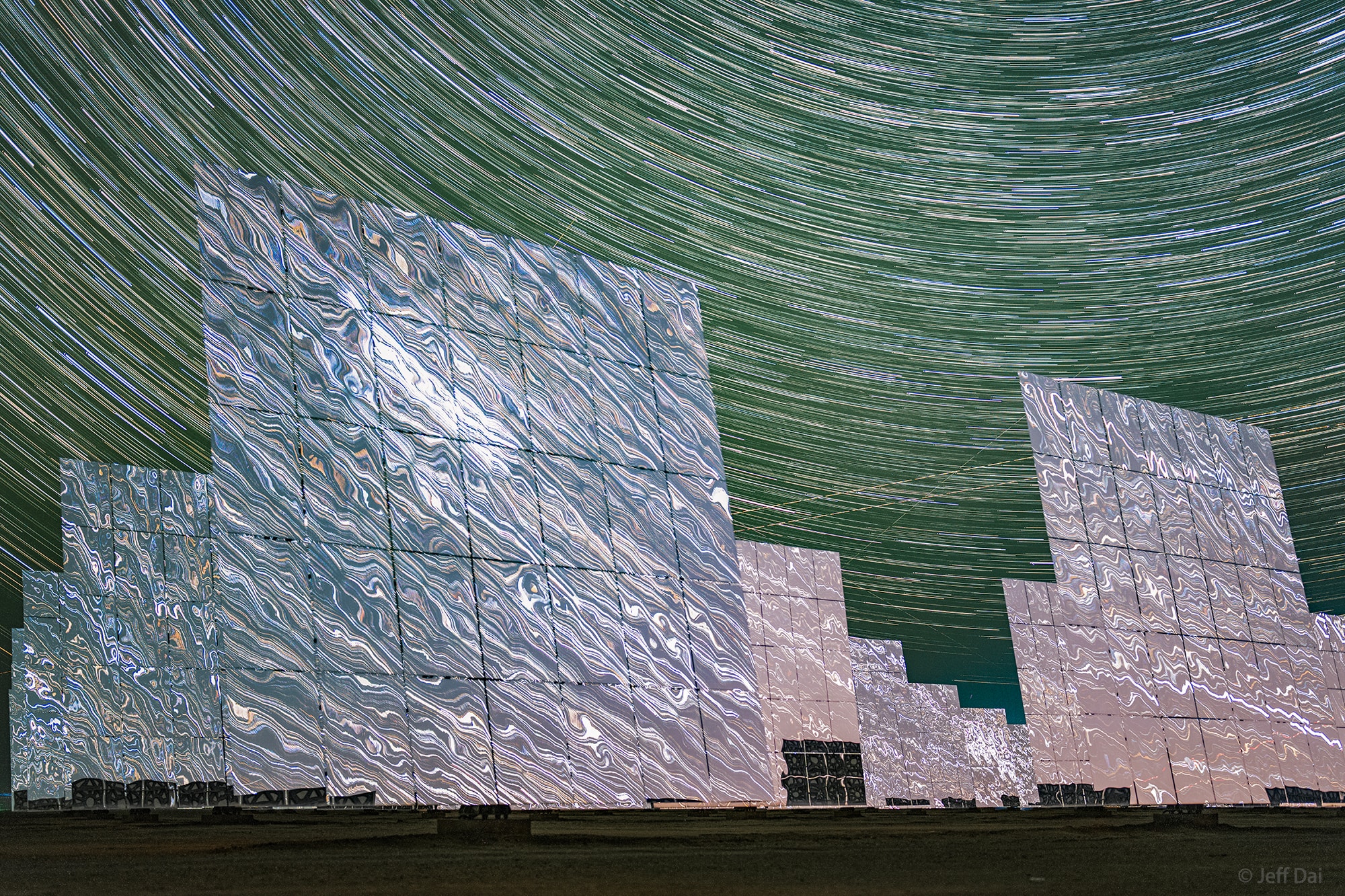 During the day, over 12,000 large mirrors reflect sunlight at the 100-megawatt, molten-salt, solar thermal power plant at the western edge of the Gobi desert near Dunhuang, Gansu Province, China. Individual mirror panels turn to track the sun like sunflowers. They conspire to act as a single super mirror reflecting the sunlight toward a fixed position, the power station's central tower. During the night the mirrors stand motionless though. They reflect the light of the countless distant stars, clusters and nebulae of the Milky Way and beyond. This sci-fi night skyscape was created with a camera fixed to a tripod near the edge of the giant mirror matrix on September 15. The camera's combined sequence of digital exposures captures concentric arcs of celestial star trails through the night with star trails in surreal mirrored reflection.