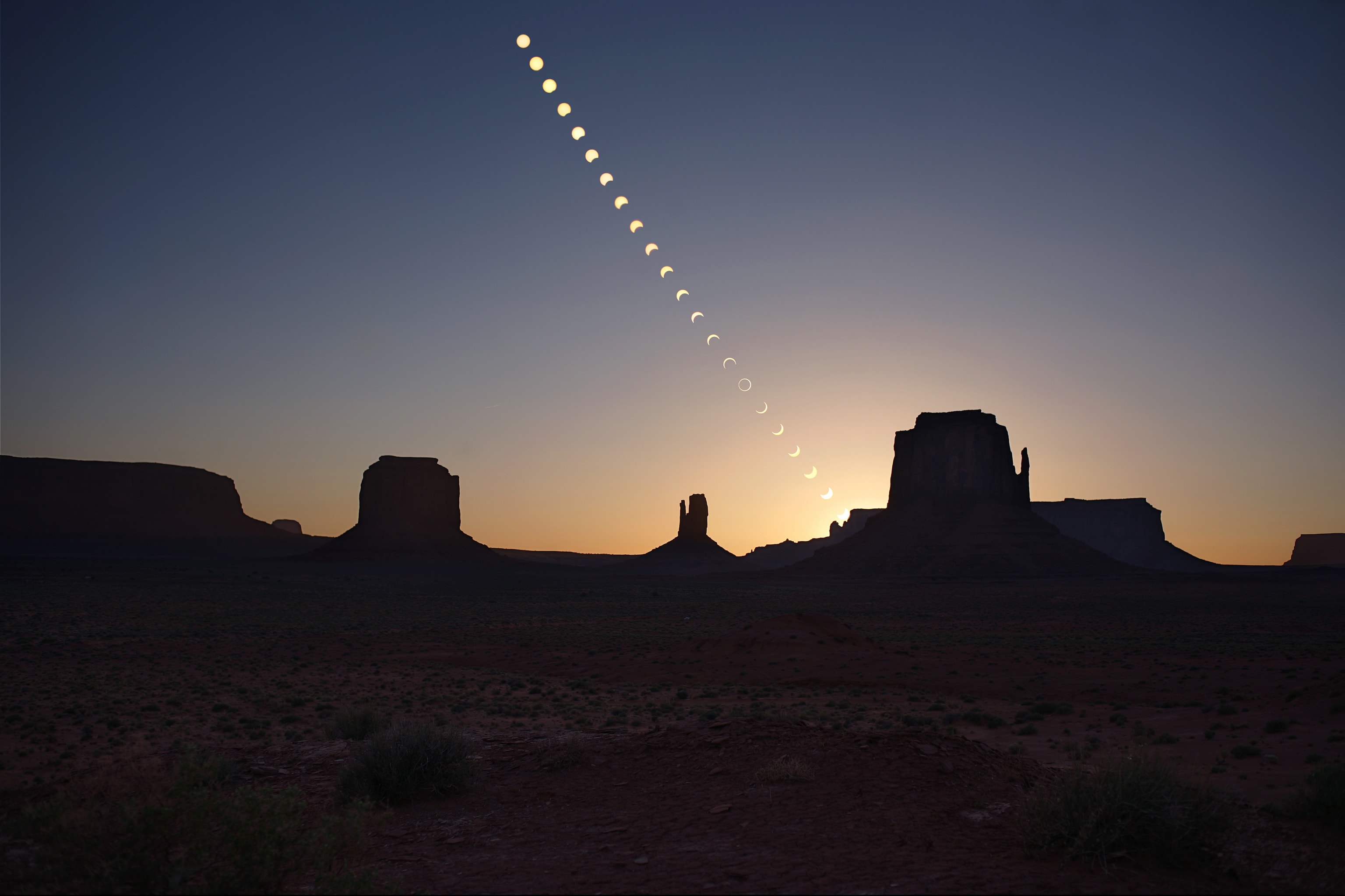 Tracking along a narrow path, the shadow of a new moon will race across North, Central, and South America, on October 14. When viewed from the shadow path the apparent size of the lunar disk will not quite completely cover the Sun though. Instead, the moon in silhouette will appear during the minutes of totality surrounded by a fiery ring, an annular solar eclipse more dramatically known as a ring of fire eclipse. This striking time lapse sequence from May of 2012 illustrates the stages of a ring of fire eclipse. From before eclipse start until sunset, they are seen over the iconic buttes of planet Earth's Monument Valley. Remarkably, the October 14 ring of fire eclipse will also be visible over Monument Valley, beginning after sunrise in the eastern sky.