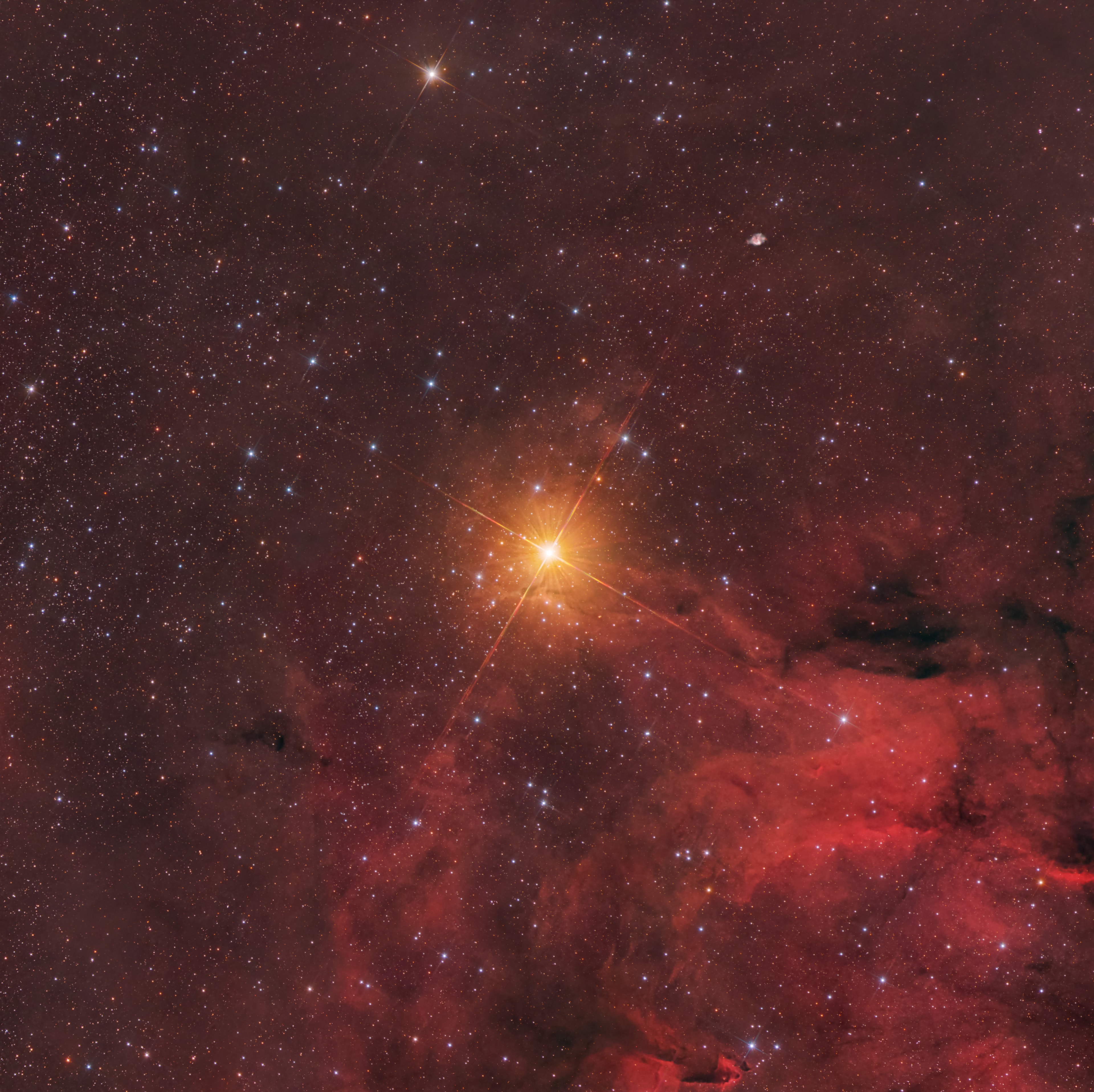 Mu Cephei is a very large star. An M-class supergiant some 1500 times the size of the Sun, it is one of the largest stars visible to the unaided eye, and even one of the largest in the entire Galaxy. If it replaced the Sun in our fair Solar System, Mu Cephei would easily engulf Mars and Jupiter. Historically known as Herschel's Garnet Star, Mu Cephei is extremely red. Approximately 2800 light-years distant, the supergiant is seen near the edge of reddish emission nebula IC 1396 toward the royal northern constellation Cepheus in this telescopic view. Much cooler and hence redder than the Sun, this supergiant's light is further reddened by absorption and scattering due to intervening dust within the Milky Way. A well-studied variable star understood to be in a late phase of stellar evolution, Mu Cephei is a massive star too, destined to ultimately explode as a core-collapse supernova.