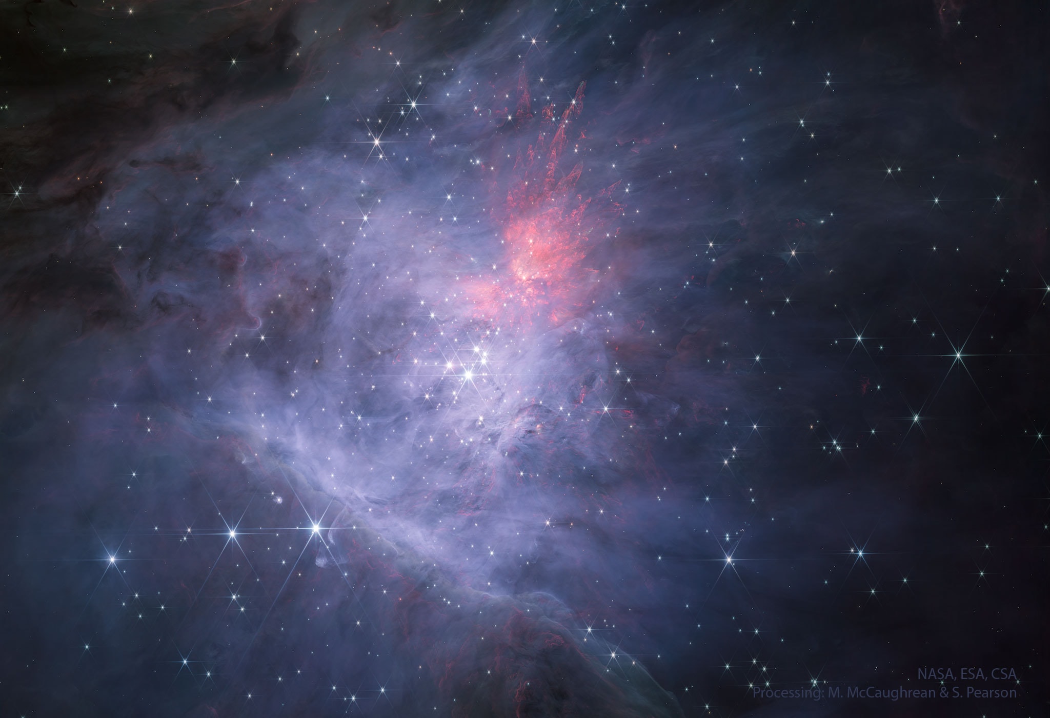 The Great Nebula in Orion has hidden stars.   To the unaided eye in visible light, it appears as a small fuzzy patch in the constellation of Orion. But this image was taken by the Webb Space Telescope in a representative-color composite of red and very near infrared light.  It confirms with impressive detail that the  Orion Nebula is a busy neighborhood of young stars, hot gas, and dark dust.  The rollover image shows the same image in representative colors further into the near infrared. The power behind much of the Orion Nebula (M42) is the Trapezium - a cluster of bright stars near the nebula's center.  The diffuse and filamentary glow surrounding the bright stars is mostly heated interstellar dust.  Detailed inspection of these images shows an unexpectedly large number of Jupiter-Mass Binary Objects (JuMBOs), pairs of Jupiter-mass objects which might give a clue to how stars are forming.  The whole Orion Nebula cloud complex, which includes the Horsehead Nebula, will slowly disperse over the next few million years.   APOD editor to speak: in Houghton, Michigan on Thursday, October 12 at 6 pm