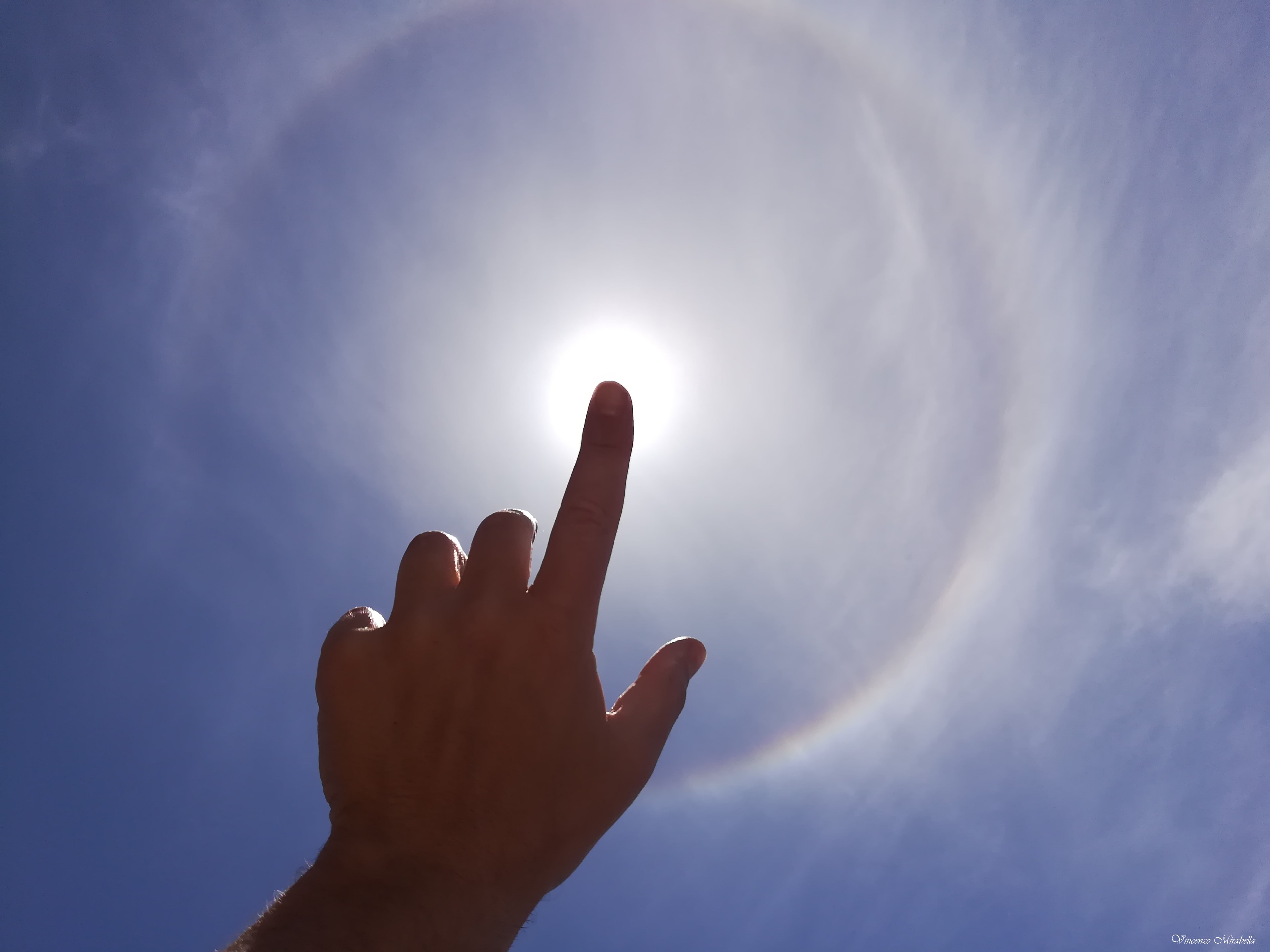 Want to see a ring around the Sun? It's easy to do in daytime skies around the world. Created by randomly oriented ice crystals in thin high cirrus clouds, circular 22 degree halos are visible much more often than rainbows. This one was captured by smart phone photography on May 29, 2021 near Rome, Italy. Carefully blocking the Sun, for example with a finger tip, is usually all that it takes to reveal the common bright halo ring. The halo's characteristic angular radius is about equal to the span of your hand, thumb to little finger, at the end of your outstretched arm.  Want to see a ring of fire eclipse? That's harder. The spectacular annular phase of today's (October 14) solar eclipse, known as a ring of fire, is briefly visible only when standing along the Moon's narrow shadow track that passes over limited parts of North, Central, and South America. The solar eclipse is partial though, when seen from broader regions throughout the Americas.   Album growing: Selected eclipse images sent in to APOD