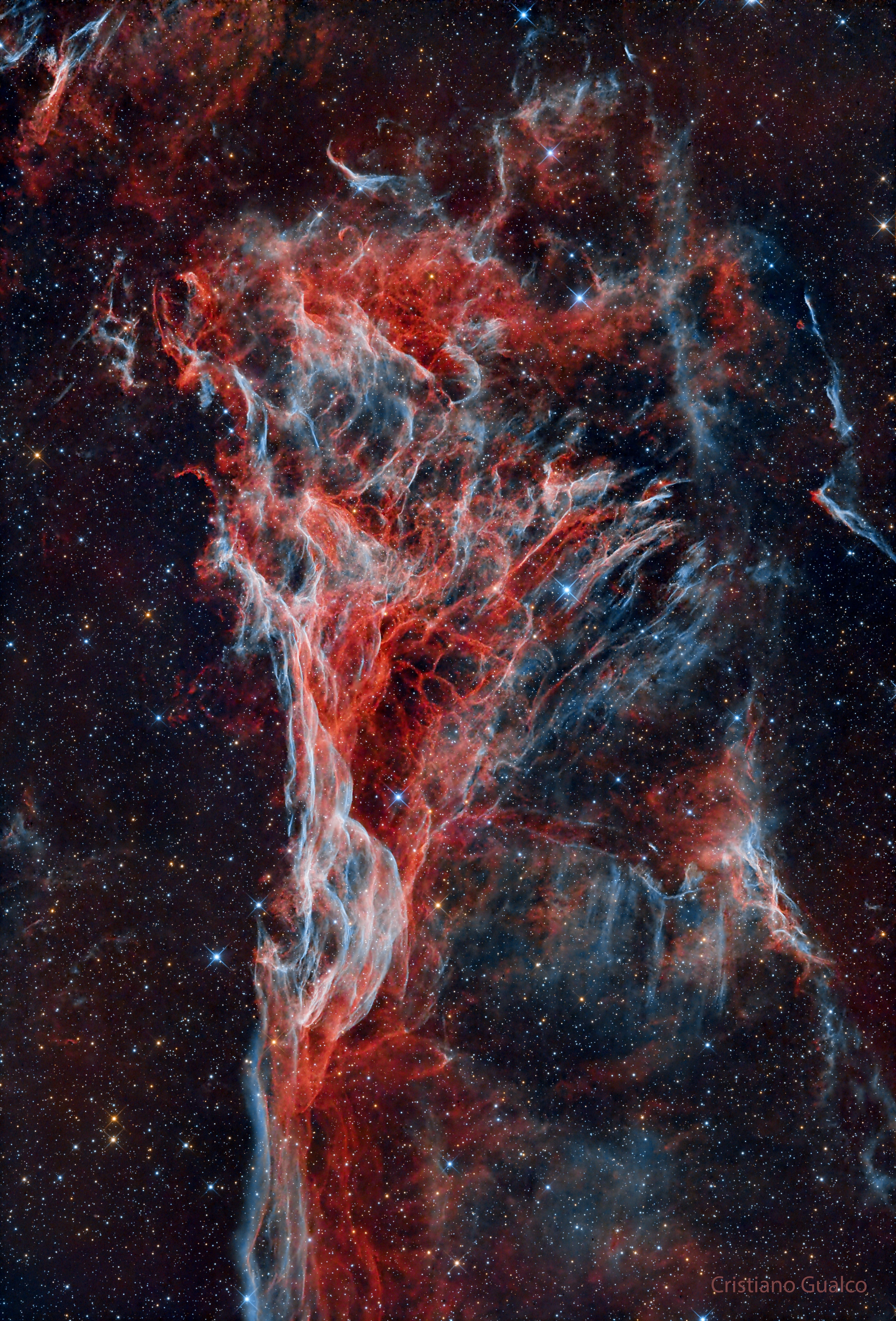 These chaotic and tangled filaments of shocked, glowing gas are spread across planet Earth's sky toward the constellation of Cygnus as part of the Veil Nebula. The Veil Nebula itself is a large supernova remnant, an expanding cloud born of the death explosion of a massive star. Light from the original supernova explosion likely reached Earth over 5,000 years ago. The glowing filaments are really more like long ripples in a sheet seen almost edge on, remarkably well separated into the glow of ionized hydrogen atoms shown in red and oxygen in blue hues. Also known as the Cygnus Loop and cataloged as NGC 6979, the Veil Nebula now spans about 6 times the diameter of the full Moon. The length of the wisp corresponds to about 30 light years, given its estimated distance of 2,400 light years.  Often identified as Pickering's Triangle for a director of Harvard College Observatory, it is perhaps better named for its discoverer, astronomer Williamina Fleming, as Fleming's Triangular Wisp.   New: Follow APOD on Telegram