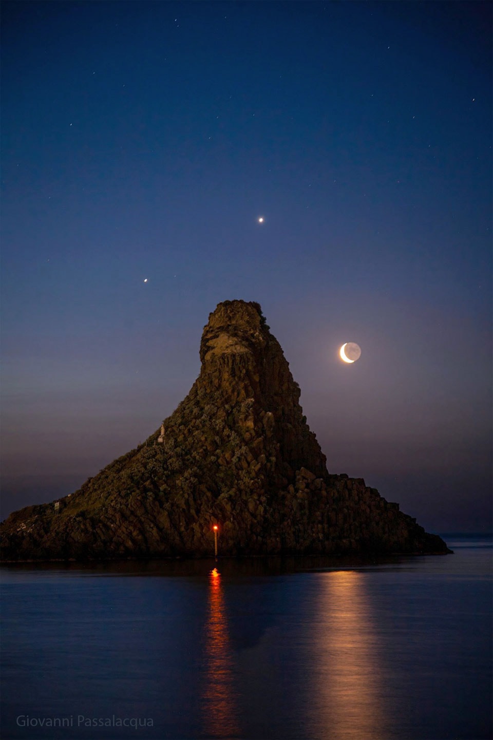 In the fading darkness before dawn, a tilted triangle appeared to balance atop a rock formation off the southern tip of Sicily.  Making up the points of the triangle are three of the four brightest objects visible in Earth’s sky: Jupiter, Venus and the Moon.  Though a thin waning crescent, most of the moon’s disk is visible due to earthshine.  Captured in this image on 2022 April 27, Venus (center) and Jupiter (left) are roughly three degrees apart --  and were headed toward a close conjunction.  Conjunctions of Venus and Jupiter occur about once a year and are visible either in the east before sunrise or in the west after sunset.  The featured image was taken about an hour before the arrival of the brightest object in Earth’s sky – the Sun.