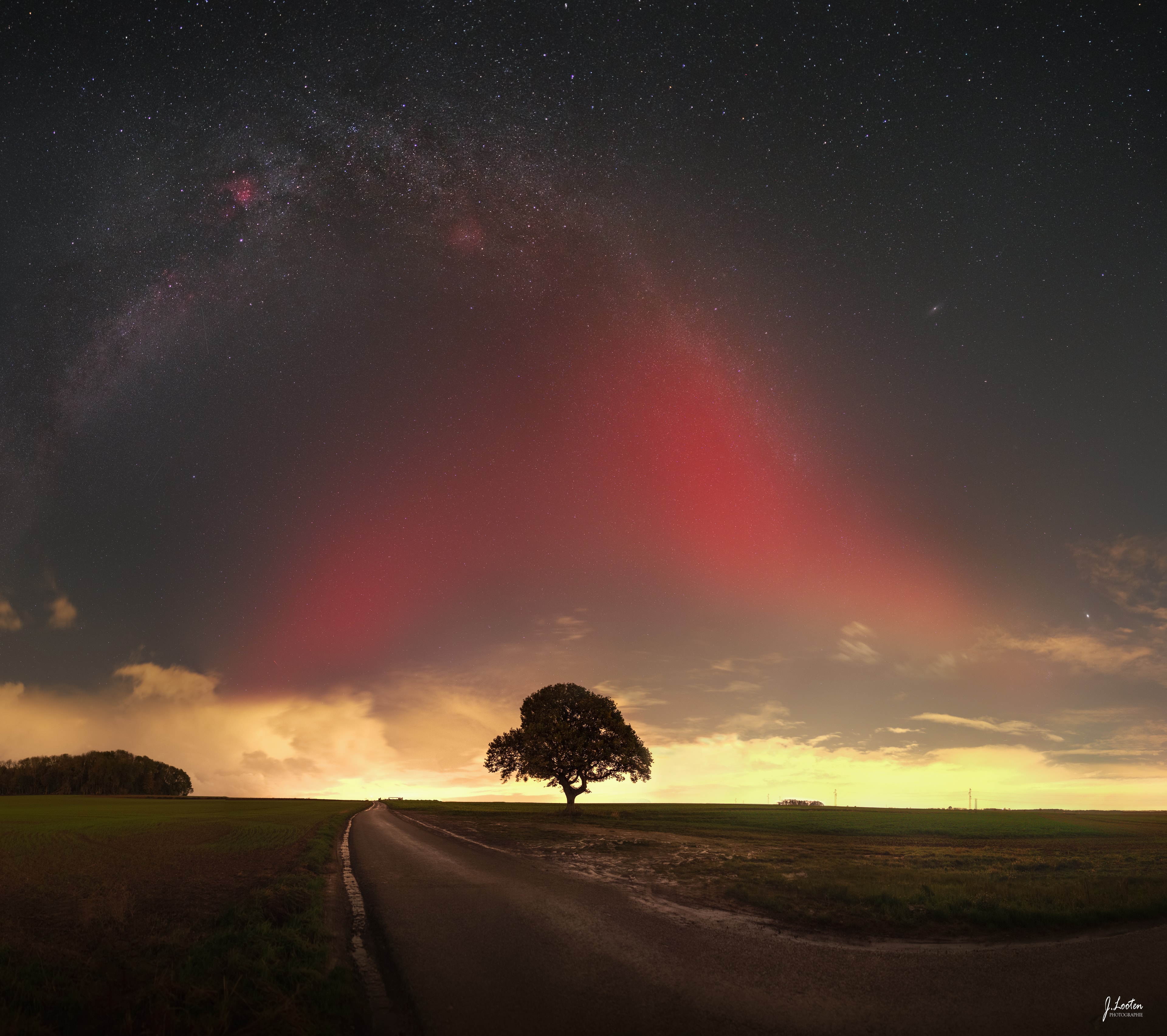 This broad, luminous red arc was a surprising visitor to partly cloudy evening skies over northern France. Captured extending toward the zenith in a west-to-east mosaic of images from November 5, the faint atmospheric ribbon of light is an example of a Stable Auroral Red (SAR) arc. The rare night sky phenomenon was also spotted at unusually low latitudes around world, along with more dynamic auroral displays during an intense geomagnetic storm. SAR arcs and their relation to auroral emission have been explored by citizen science and satellite investigations. From altitudes substantially above the normal auroral glow, the deep red SAR emission is thought to be caused by strong heating due to currents flowing in planet Earth's inner magnetosphere. Beyond this SAR, the Milky Way arcs above the cloud banks along the horizon, a regular visitor to night skies over northern France.