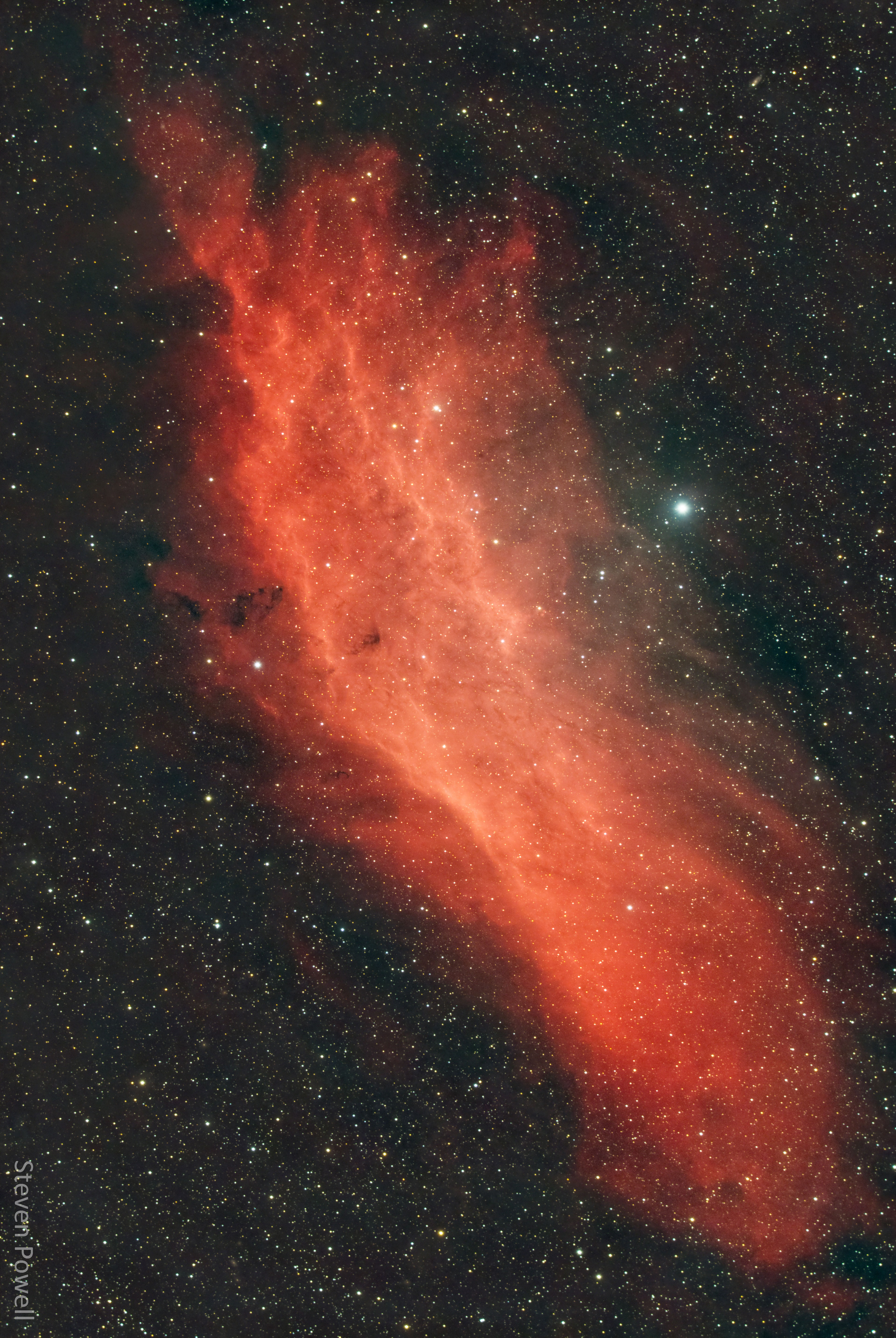 Could Queen Calafia's mythical island exist in space? Perhaps not, but by chance the outline of this molecular space cloud echoes the outline of the state of California, USA. Our Sun has its home within the Milky Way's Orion Arm, only about 1,000 light-years from the California Nebula. Also known as NGC 1499, the classic emission nebula is around 100 light-years long. On the featured image, the most prominent glow of the California Nebula is the red light characteristic of hydrogen atoms recombining with long lost electrons, stripped away (ionized) by energetic starlight. The star most likely providing the energetic starlight that ionizes much of the nebular gas is the bright, hot, bluish Xi Persei just to the right of the nebula.  A regular target for astrophotographers, the California Nebula can be spotted with a wide-field telescope under a dark sky toward the constellation of Perseus, not far from the Pleiades.   Explore Your Universe: Random APOD Generator