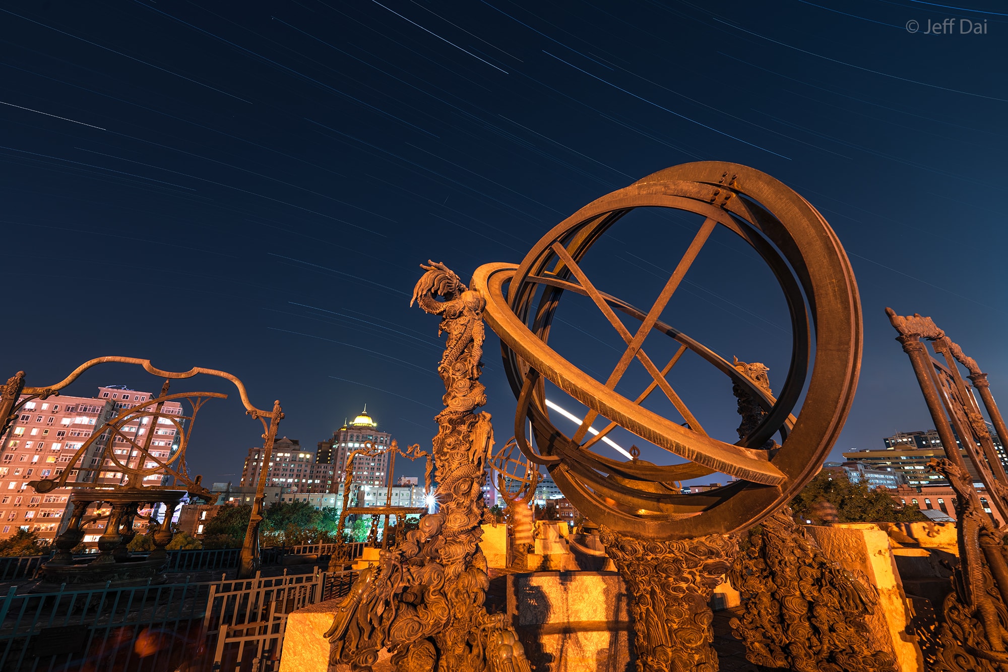 You can take a subway ride to visit this observatory in Beijing, China but you won't find any telescopes there. Starting in the 1400s astronomers erected devices at the Beijing Ancient Observatory site to enable them to accurately measure and track the positions of naked-eye stars and planets. Some of the large, ornate astronomical instruments are still standing. You can even see stars from the star observation platform today, but now only the very brightest celestial beacons are visible against the city lights. In this time series of exposures from a camera fixed to a tripod to record graceful arcing startrails, the brightest trail is actually the Moon. Its broad arc is seen behind the ancient observatory's brass armillary sphere. Compare this picture from the Beijing Ancient Observatory taken in September 2023 to one taken in 1895.