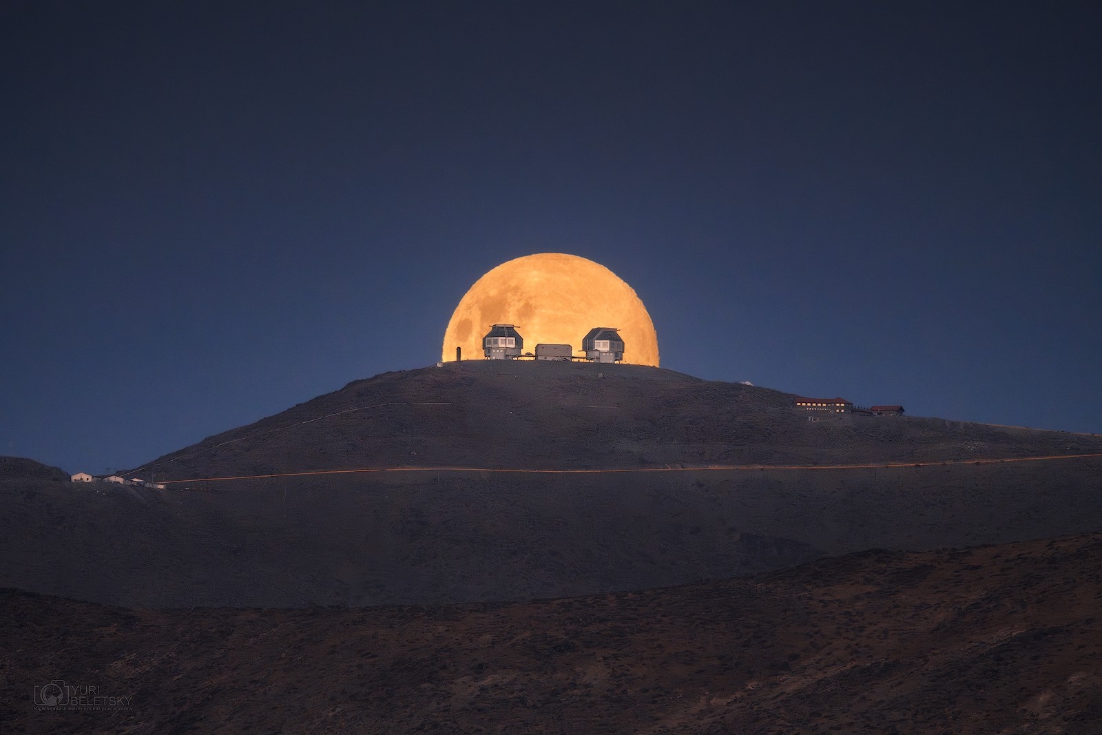 A popular name for January's full moon in the northern hemisphere is the Full Wolf Moon. As the new year's first full moon, it rises over Las Campanas Observatory in this dramatic Earth-and-moonscape. Peering from the foreground like astronomical eyes are the observatory's twin 6.5 meter diameter Magellan telescopes. The snapshot was captured with telephoto lens across rugged terrain in the Chilean Atacama Desert, taken at a distance of about 9 miles from the observatory and about 240,000 miles from the lunar surface. Of course the first full moon of the lunar new year, known to some as the Full Snow Moon, will rise on February 24.