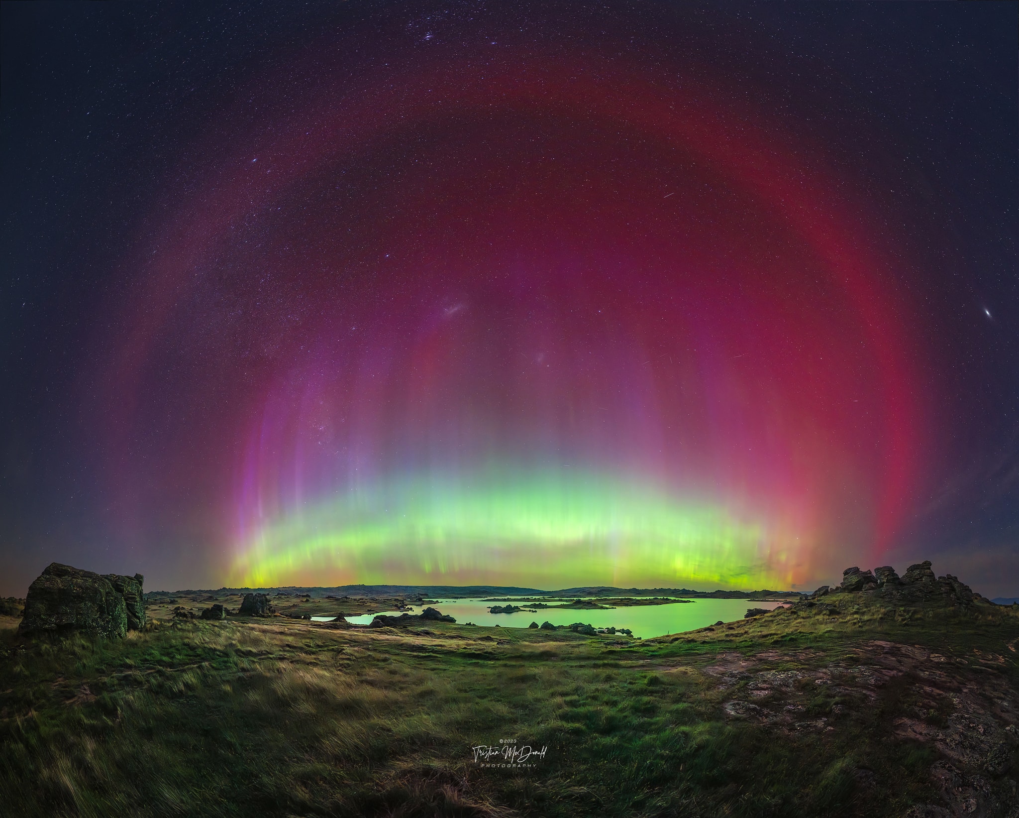 What is that unusual red halo surrounding this aurora?  It is a Stable Auroral Red (SAR) arc. SAR arcs are rare and have only been acknowledged and studied since 1954.  The featured wide-angle photograph, capturing nearly an entire SAR arc surrounding more common green and red aurora, was taken earlier this month from Poolburn, New Zealand, during an especially energetic geomagnetic storm. Why SAR arcs form remains a topic of research, but is likely related to Earth's protective magnetic field, a field created by molten iron flowing deep inside the Earth.  This magnetic field usually redirects incoming charged particles from the Sun's wind toward the Earth's poles. However, it also traps a ring of ions closer to the equator, where they can gain energy from the magnetosphere during high solar activity. The energetic electrons in this ion ring can collide with and excite oxygen higher in Earth's ionosphere than typical auroras, causing the oxygen to glow red. Ongoing research has uncovered evidence that a red SAR arc can even transform into a purple and green STEVE.