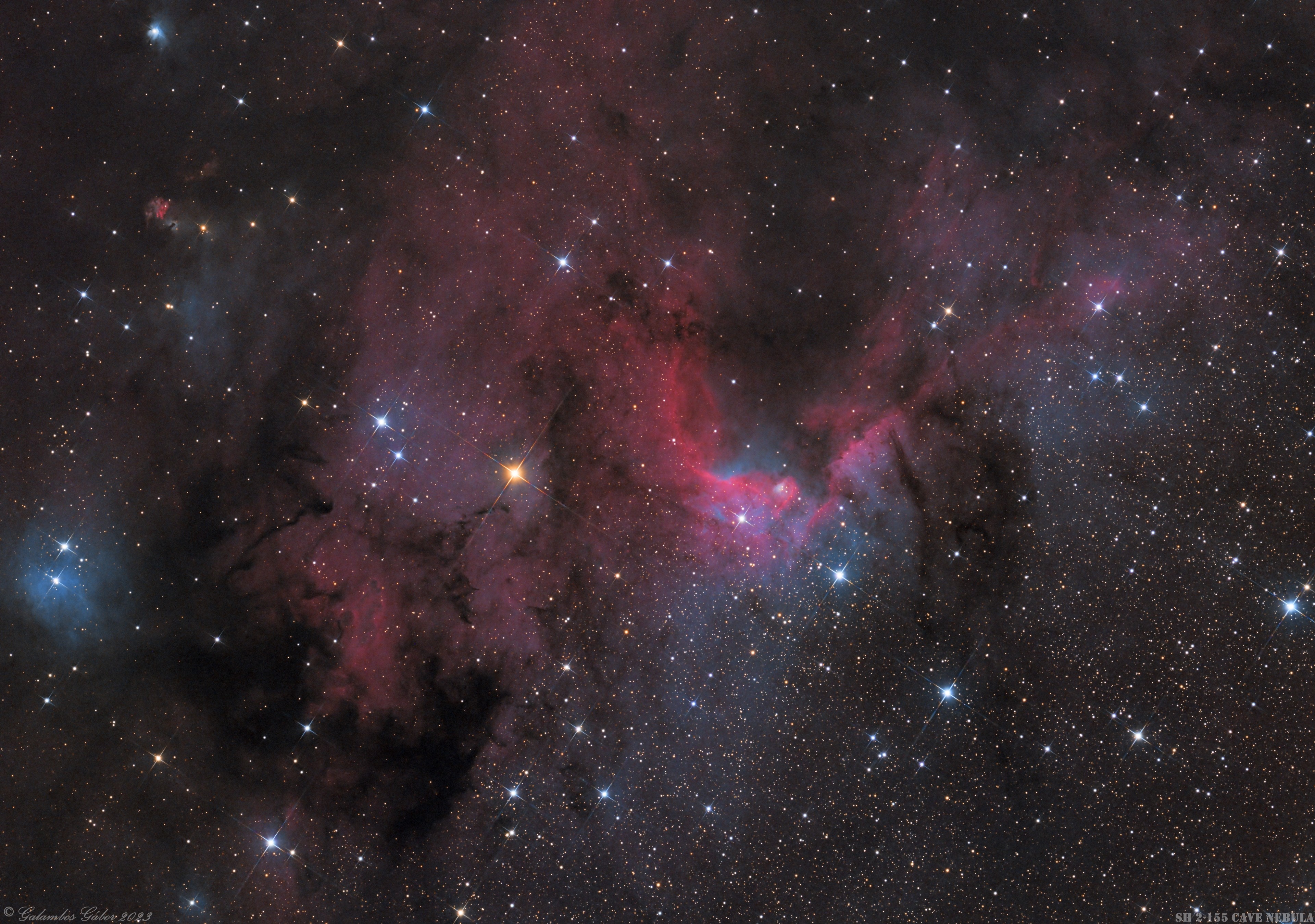 This colorful skyscape spans about three full moons across nebula rich starfields along the plane of our Milky Way Galaxy toward the royal northern constellation Cepheus. Near the edge of the region's massive molecular cloud some 2,400 light-years away, bright reddish emission region Sharpless (Sh)2-155 is at the center of the frame, also known as the Cave Nebula. About 10 light-years across the cosmic cave's bright walls of gas are ionized by ultraviolet light from the hot young stars around it. Dusty bluish reflection nebulae, like vdB 155 at the left, and dense obscuring clouds of dust also abound on the interstellar canvas. Astronomical explorations have revealed other dramatic signs of star formation, including the bright reddish fleck of Herbig-Haro (HH) 168. At the upper left in the frame, the Herbig-Haro object emission is generated by energetic jets from a newborn star.