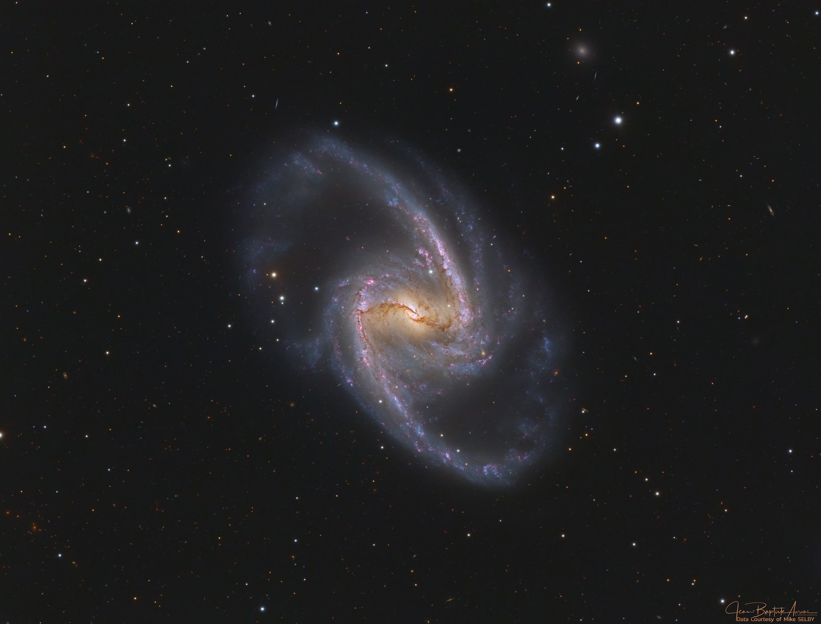 Barred spiral galaxy NGC 1365 is truly a majestic island universe some 200,000 light-years across. Located a mere 60 million light-years away toward the faint but heated constellation Fornax, NGC 1365 is a dominant member of the well-studied Fornax Cluster of galaxies. This sharp color image shows the intense, reddish star forming regions near the ends of the galaxy's central bar and along its spiral arms. Seen in fine detail, obscuring dust lanes cut across the galaxy's bright core. At the core lies a supermassive black hole. Astronomers think NGC 1365's prominent bar plays a crucial role in the galaxy's evolution, drawing gas and dust into a star-forming maelstrom and ultimately feeding material into the central black hole.