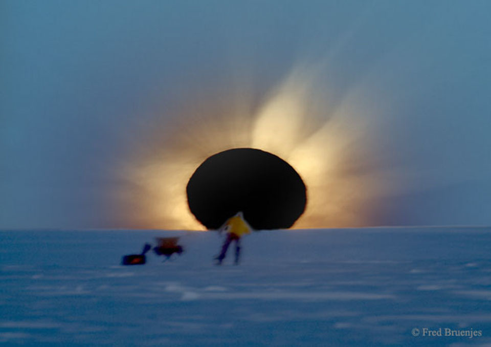 Would you go to the end of the world to see a total eclipse of the Sun? If you did, would you be surprised to find someone else there already? In 2003, the Sun, the Moon, Antarctica, and two photographers all lined up in Antarctica during an unusual total solar eclipse.  Even given the extreme location, a group of enthusiastic eclipse chasers ventured near the bottom of the world to experience the surreal momentary disappearance of the Sun behind the Moon.  One of the treasures collected was the featured picture -- a composite of four separate images digitally combined to realistically simulate how the adaptive human eye saw the eclipse.  As the image was taken, both the Moon and the Sun peeked together over an Antarctic ridge.  In the sudden darkness, the magnificent corona of the Sun became visible around the Moon.  Quite by accident, another photographer was caught in one of the images checking his video camera.   Visible to his left are an equipment bag and a collapsible chair.  A more easily visible solar eclipse will occur in just under four weeks and be visible from a long, thin swath of North America.