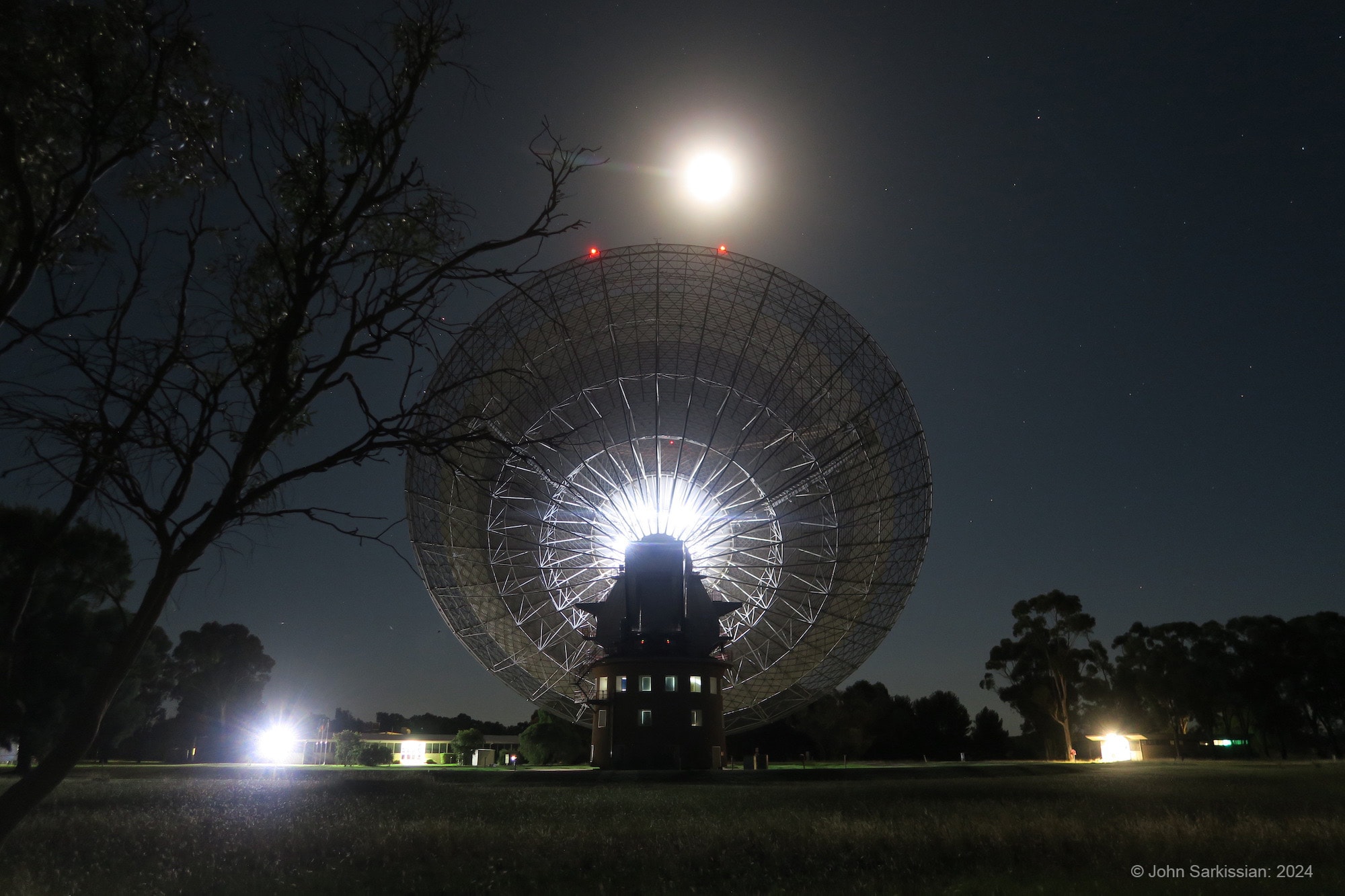 Murriyang, the CSIRO’s Parkes Radio Telescope, points toward a nearly Full Moon in this image from New South Wales, Australia, planet Earth. Bathed in moonlight, the 64 meter dish is receiving weak radio signals from Odysseus, following the robotic lander's February 22 touch down some 300 kilometers north of the Moon's south pole. The landing of Odysseus represents the first U.S. landing on the Moon since the Apollo 17 mission in 1972. Odysseus' tilted orientation on the lunar surface prevents its high-gain antenna from pointing toward Earth. But the sensitivity of the large, steerable Parkes dish significantly improved the reception of data from the experiments delivered to the lunar surface by the robotic moon lander. Of course the Parkes Radio Telescope dish became famous for its superior lunar television reception during the Apollo 11 mission in 1969, allowing denizens of planet Earth to watch the first moonwalk.