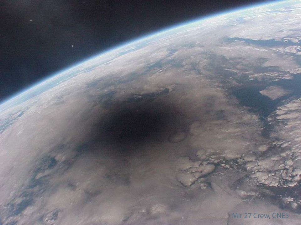 Here is what the Earth looks like during a solar eclipse. The shadow of the Moon can be seen darkening part of Earth. This shadow moved across the Earth at nearly 2000 kilometers per hour. Only observers near the center of the dark circle see a total solar eclipse - others see a partial eclipse where only part of the Sun appears blocked by the Moon. This spectacular picture of the 1999 August 11 solar eclipse was one of the last ever taken from the Mir space station. The two bright spots that appear on the upper left are thought to be Jupiter and Saturn. Mir was deorbited in a controlled re-entry in 2001. A new solar eclipse will occur over North America in about two weeks.