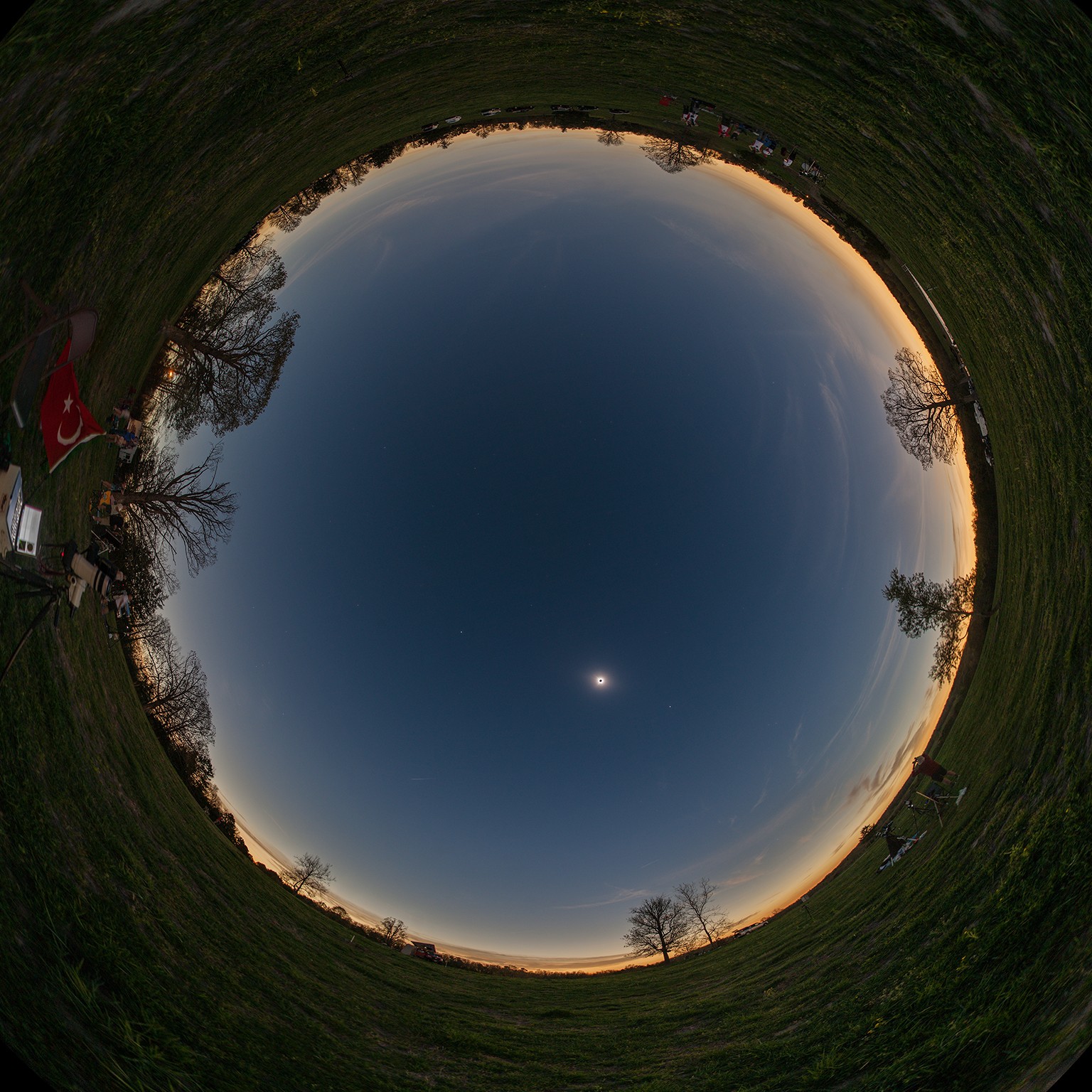 If the Sun is up but the sky is dark and the horizon is bright all around, you might be standing in the Moon's shadow during a total eclipse of the Sun. In fact, the all-sky Moon shadow shown in this composited panoramic view was captured from a farm near Shirley, Arkansas, planet Earth. The exposures were made under clear skies during the April 8 total solar eclipse. For that location near the center line of the Moon's shadow track, totality lasted over 4 minutes. Along with the solar corona surrounding the silhouette of the Moon planets and stars were visible during the total eclipse phase. Easiest to see here are bright planets Venus and Jupiter, to the lower right and upper left of the eclipsed Sun.