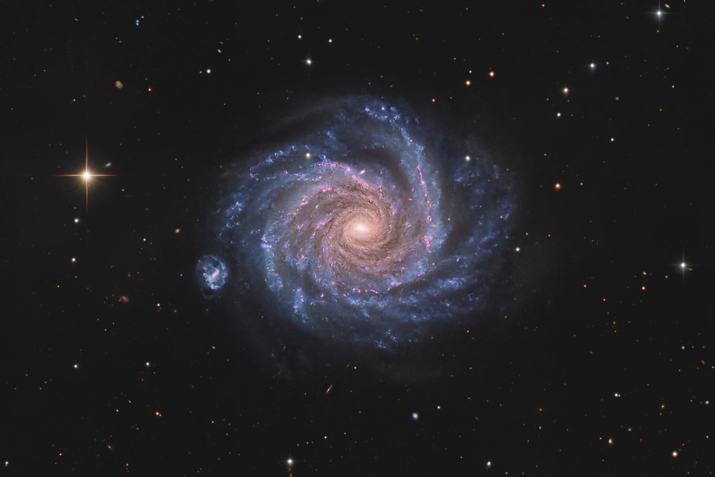 From our vantage point in the Milky Way Galaxy, we see NGC 1232 face-on. Nearly 200,000 light-years across, the big, beautiful spiral galaxy is located some 47 million light-years away in the flowing southern constellation of Eridanus. This sharp, multi-color, telescopic image of NGC 1232 includes remarkable details of the distant island universe. From the core outward, the galaxy's colors change from the yellowish light of old stars in the center to young blue star clusters and reddish star forming regions along the grand, sweeping spiral arms. NGC 1232's apparent, small, barred-spiral companion galaxy is cataloged as NGC 1232A. Distance estimates place it much farther though, around 300 million light-years away, and unlikely to be interacting with NGC 1232.  Of course, the prominent bright star with the spiky appearance is much closer than NGC 1232 and lies well within our own Milky Way.