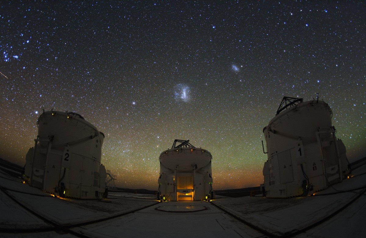 Despite their resemblance to R2D2, these three are not the droids you're looking for. Instead, the enclosures house 1.8 meter Auxiliary Telescopes (ATs) at Paranal Observatory in the Atacama Desert region of Chile. The ATs are designed to be used for interferometry, a technique for achieving extremely high resolution observations, in concert with the observatory's 8 meter Very Large Telescope units. A total of four ATs are operational, each fitted with a transporter that moves the telescope along a track allowing different arrays with the large unit telescopes. To work as an interferometer, the light from each telescope is brought to a common focal point by a system of mirrors in underground tunnels. Above these three ATs, the Large and Small Magellanic Clouds are the far, far away satellite galaxies of our own Milky Way. In the clear and otherwise dark southern skies, planet Earth's greenish atmospheric airglow stretches faintly along the horizon.