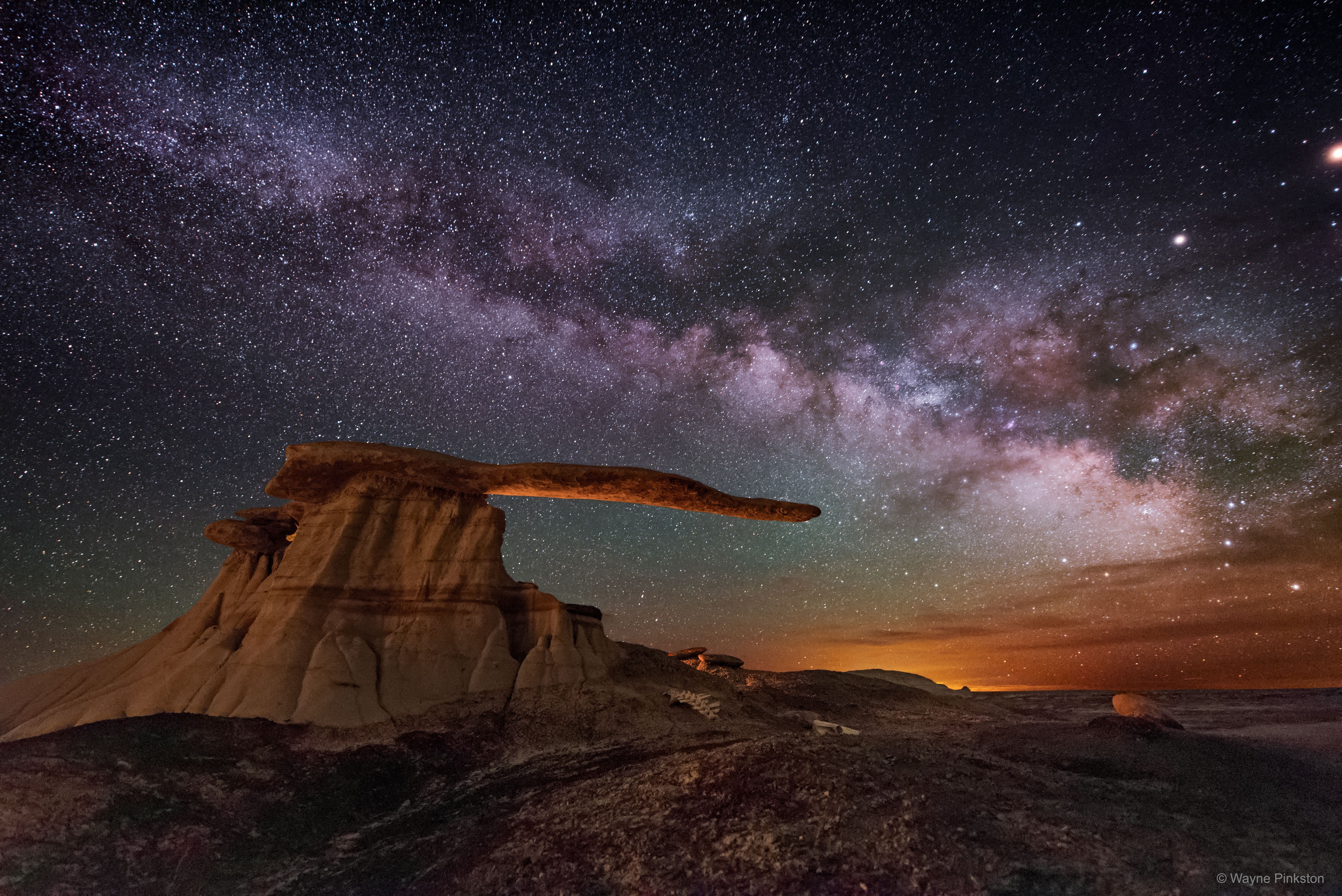 This rock structure is not only surreal -- it's real.  Perhaps the reason it's not more famous is that it is smaller than one might guess: the capstone rock overhangs only a few meters.  Even so, the King of Wings outcrop, located in New Mexico, USA, is a fascinating example of an unusual type of rock structure called a hoodoo. Hoodoos may form when a layer of hard rock overlays a layer of eroding softer rock. Figuring out the details of incorporating this hoodoo into a night-sky photoshoot took over a year. Besides waiting for a suitably picturesque night behind a sky with few clouds, the foreground had to be artificially lit just right relative to the natural glow of the background.  After much planning and waiting, the final shot, featured here, was taken in May 2016. Mimicking the horizontal bar, the background sky features the band of our Milky Way Galaxy stretching overhead.