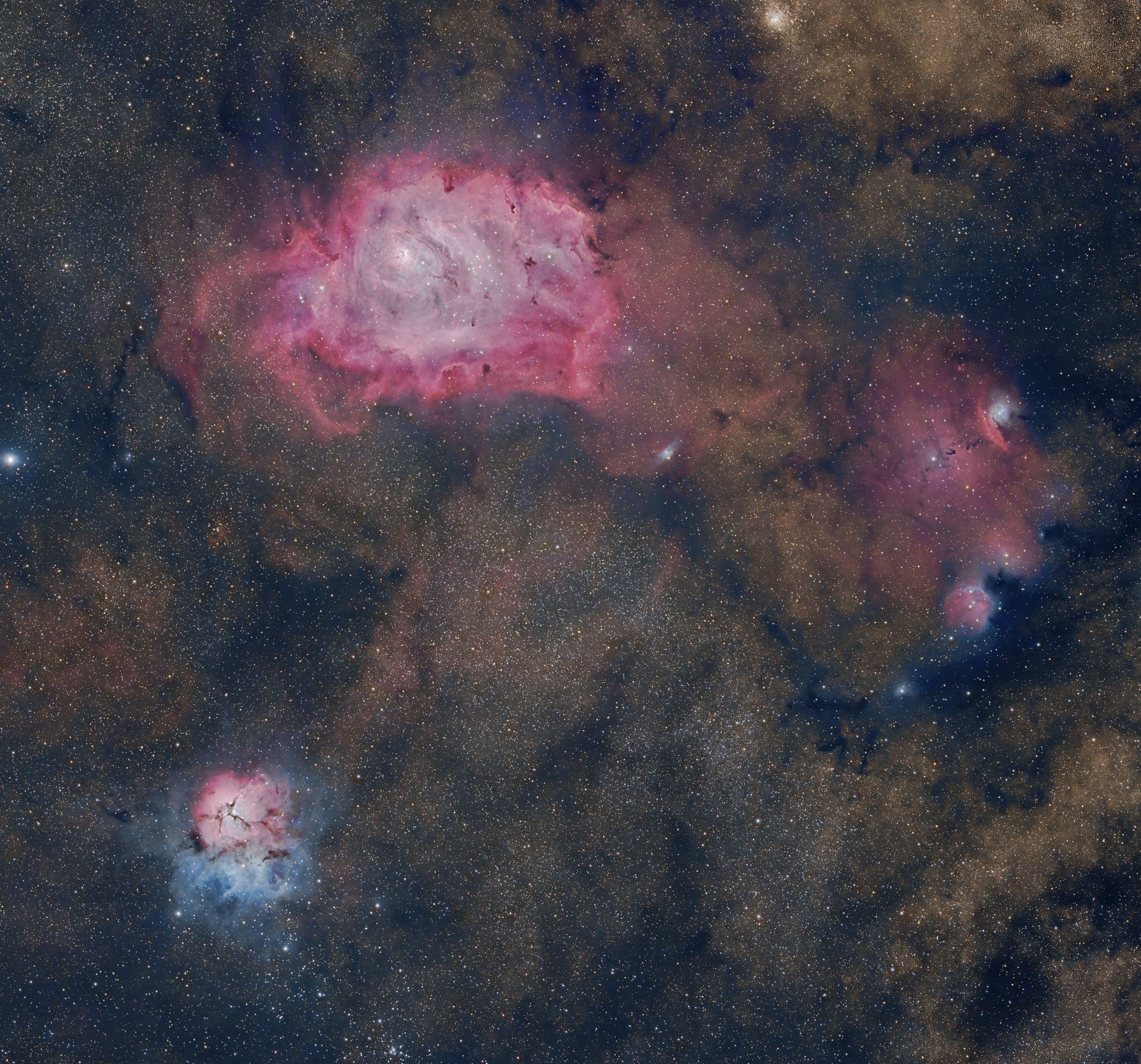 These three bright nebulae are often featured on telescopic tours of the constellation Sagittarius and the crowded starfields of the central Milky Way. In fact, 18th century cosmic tourist Charles Messier cataloged two of them; M8, the large nebula above center, and colorful M20 below and left in the frame. The third emission region includes NGC 6559, right of M8 and separated from the larger nebula by a dark dust lane. All three are stellar nurseries about five thousand light-years or so distant. Over a hundred light-years across the expansive M8 is also known as the Lagoon Nebula. M20's popular moniker is the Trifid. Glowing hydrogen gas creates the dominant red color of the emission nebulae. But for striking contrast, blue hues in the Trifid are due to dust reflected starlight. The broad interstellar skyscape spans almost 4 degrees or 8 full moons on the sky.