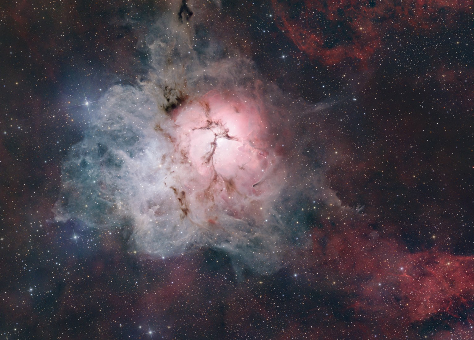 Messier 20, popularly known as the Trifid Nebula, lies about 5,000 light-years away toward the nebula rich constellation Sagittarius. A star forming region in the plane of our galaxy, the Trifid does illustrate three different types of astronomical nebulae; red emission nebulae dominated by light from hydrogen atoms, blue reflection nebulae produced by dust reflecting starlight, and dark nebulae where dense dust clouds appear in silhouette. The reddish emission region, roughly separated into three parts by obscuring dust lanes, is what lends the Trifid its popular name. The cosmic cloud complex is over 40 light-years across and would cover the area of a full moon on planet Earth's sky. But the Trifid Nebula is too faint to be seen by the unaided eye. Over 75 hours of image data captured under dark night skies was used to create this stunning telescopic view.  Watch: The Perseid Meteor Shower