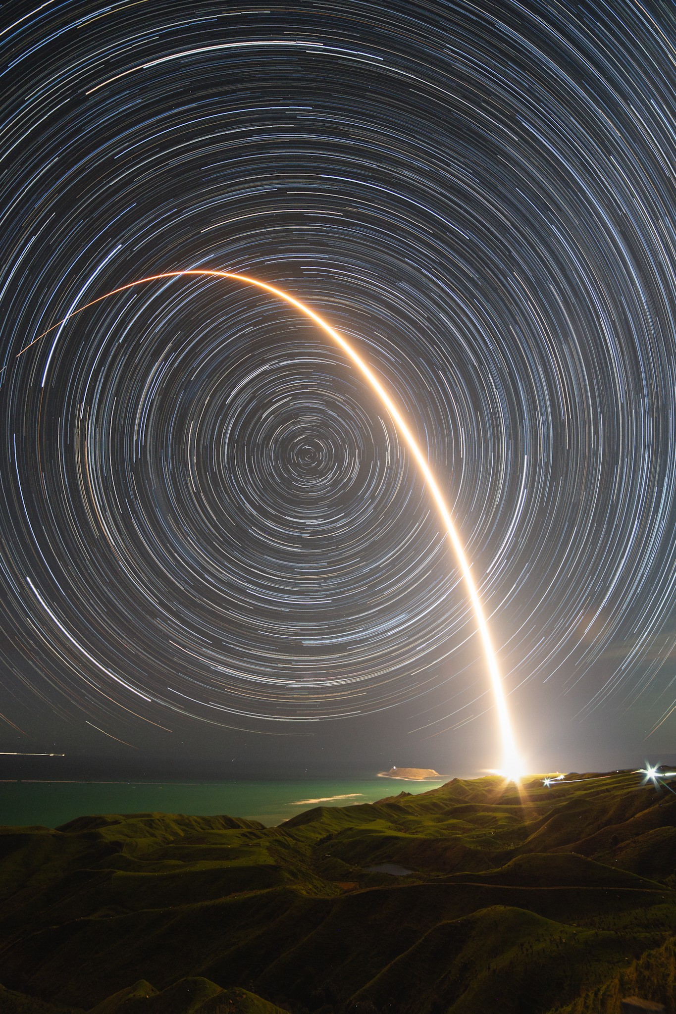 On August 11 a Rocket Lab Electron rocket launched from a rotating planet. With a small satellite on board its mission was dubbed A Sky Full of SARs (Synthetic Aperture Radar satellites), departing for low Earth orbit from Mahia Peninsula on New Zealand's north island. The fiery trace of the Electron's graceful launch arc is toward the east in this southern sea and skyscape, a composite of 50 consecutive frames taken over 2.5 hours. Fixed to a tripod, the camera was pointing directly at the South Celestial Pole, the extension of planet Earth's axis of rotation in to space. But no bright star marks that location in the southern hemisphere's night sky. Still, the South Celestial Pole is easy to spot. It lies at the center of the concentric star trail arcs that fill the skyward field of view.   Gallery: Perseid Meteor Shower 2024 and Aurorae