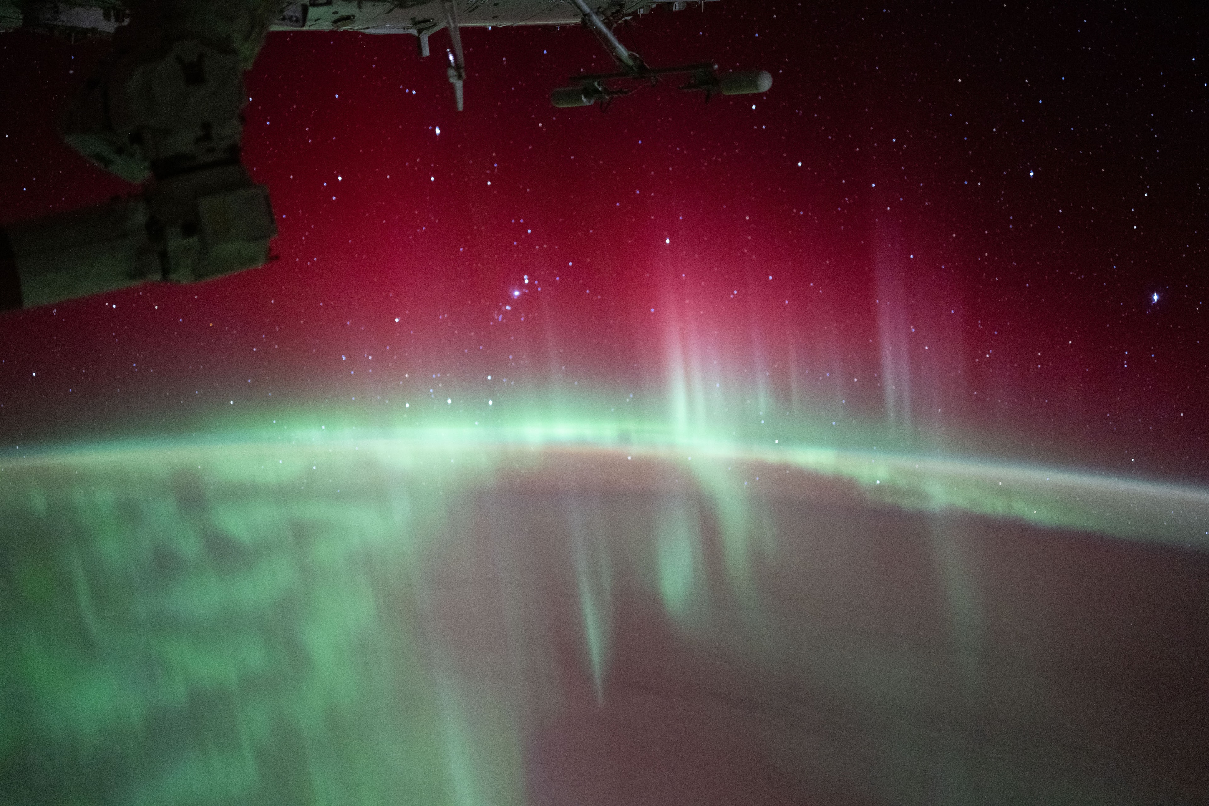 This snapshot from the International Space Station was taken on August 11 while orbiting about 430 kilometers above the Indian Ocean, Southern Hemisphere, planet Earth. The spectacular view looks south and east, down toward the planet's horizon and through red and green curtains of aurora australis. The auroral glow is caused by emission from excited oxygen atoms in the extremely rarefied upper atmosphere still present at the level of the orbiting outpost. Green emission from atomic oxygen dominates this scene at altitudes of 100 to 250 kilometers, while red emission from atomic oxygen can extend as high as 500 kilometers altitude. Beyond the glow of these southern lights, this view from low Earth orbit reveals the starry sky from a southern hemisphere perspective. Stars in Orion's belt and the Orion Nebula are near the Earth's limb just left of center. Sirius, alpha star of Canis Major and brightest star in planet Earth's night is above center along the right edge of the southern orbital skyscape.  Looking Up: International Observe the Moon Night