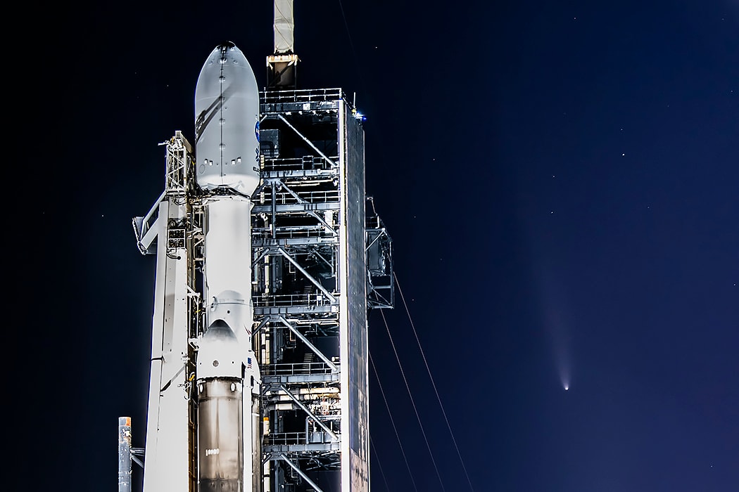 NASA's Europa Clipper is now headed toward an ocean world beyond Earth. The large spacecraft is tucked into the payload fairing atop the Falcon Heavy rocket in this photo, taken at Kennedy Space Center the day before the mission's successful October 14 launch. Europa Clipper's interplanetary voyage will first take it to Mars, then back to Earth, and then on to Jupiter on gravity assist trajectories that will allow it to enter orbit around Jupiter in April 2030. Once orbiting Jupiter, the spacecraft will fly past Europa 49 times, exploring a Jovian moon with a global subsurface ocean that may have conditions to support life. Posing in the background next to the floodlit rocket is Comet Tsuchinsan-ATLAS, about a day after the comet's closest approach to Earth. A current darling of evening skies, the naked-eye comet is a visitor from the distant Oort cloud  Growing Gallery: Comet Tsuchinshan-ATLAS in 2024