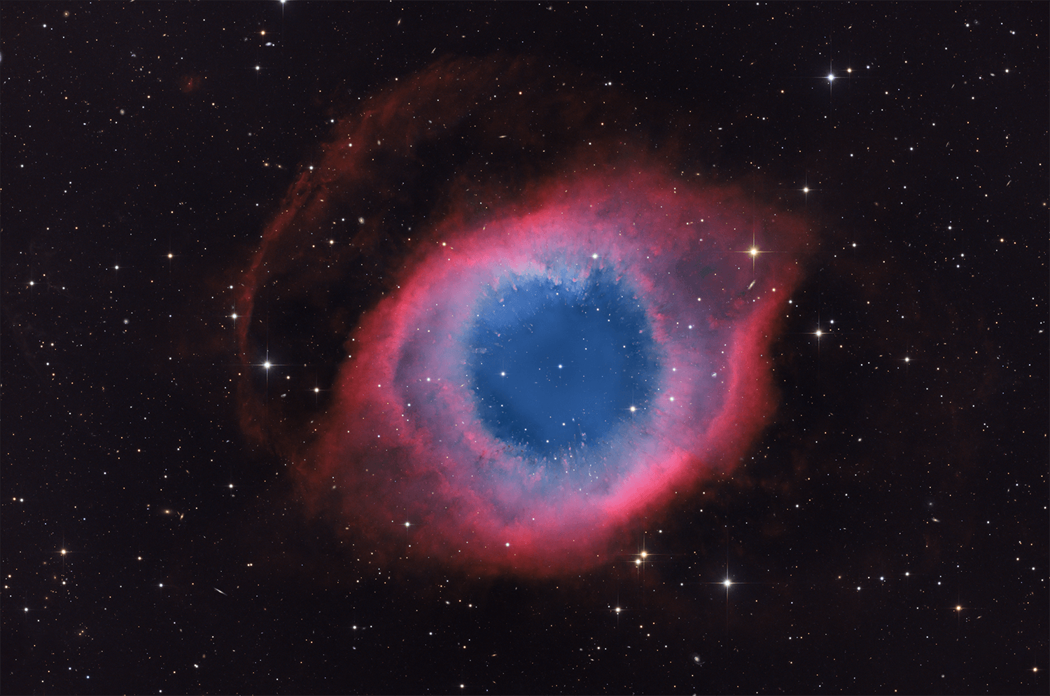 A mere seven hundred light years from Earth toward the constellation Aquarius, a star is dying. The once sun-like star's last few thousand years have produced the Helix Nebula. Also known as NGC 7293, the cosmic Helix is a well studied and nearby example of a Planetary Nebula, typical of this final phase of stellar evolution.  Combining narrow band data from emission lines of hydrogen atoms in red and oxygen atoms in blue-green hues, this deep image shows tantalizing details of the Helix, including its bright inner region about 3 light-years across. The white dot at the Helix's center is this Planetary Nebula's hot, dying central star. A simple looking nebula at first glance, the Helix is now understood to have a surprisingly complex geometry.