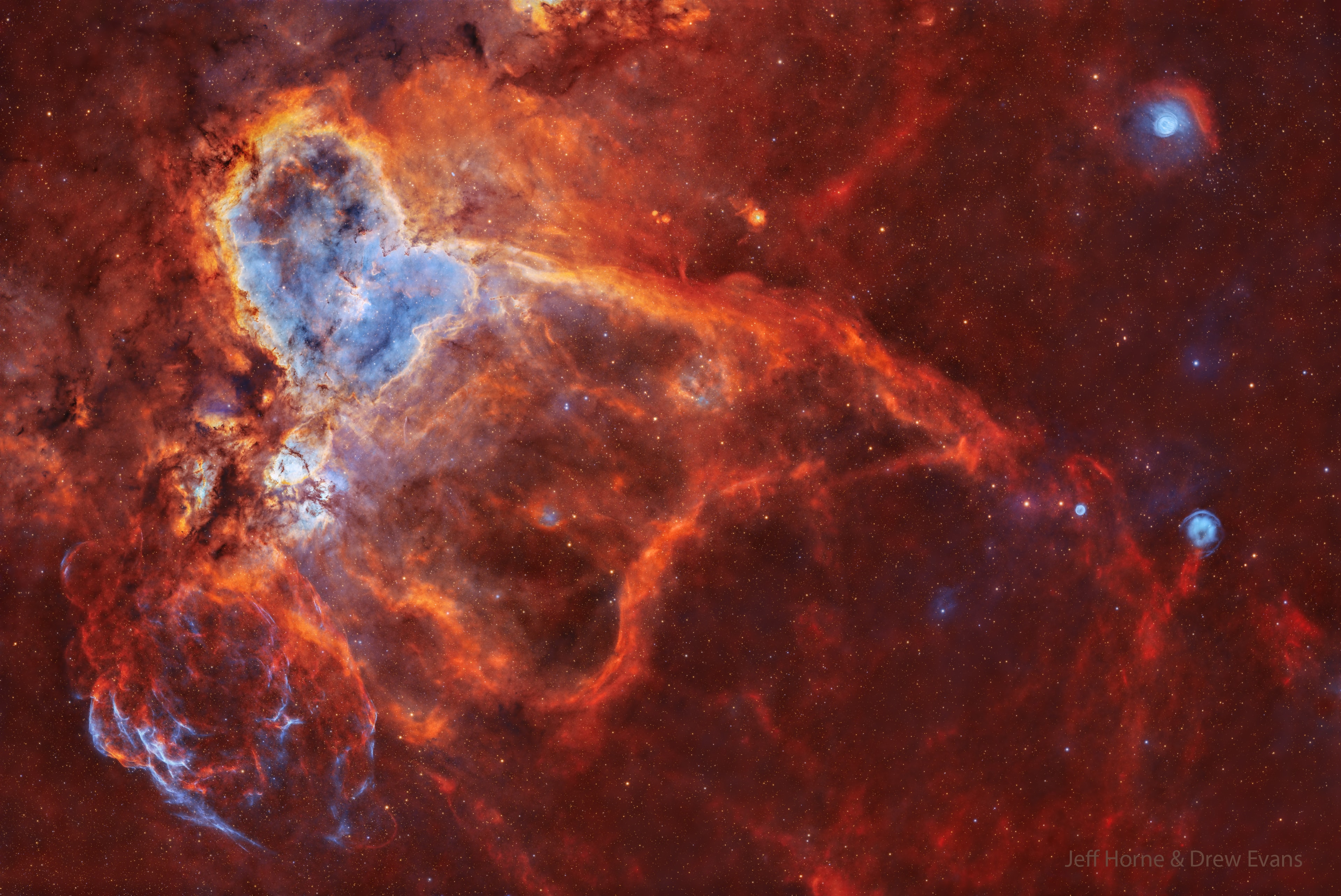 What excites the Heart Nebula? First, the large emission nebula on the upper left, catalogued as IC 1805, looks somewhat like a human heart.  The nebula glows brightly in red light emitted by its most prominent element, hydrogen, but this long-exposure image was also blended with light emitted by sulfur (yellow) and oxygen (blue).  In the center of the Heart Nebula are young stars from the open star cluster Melotte 15 that are eroding away several picturesque dust pillars with their atom-exciting energetic light and winds. The Heart Nebula is located about 7,500 light years away toward the constellation of Cassiopeia.  This wide field image shows much more, though, including the Fishhead Nebula just below the Heart, a supernova remnant on the lower left, and three planetary nebulas on the image right.  Taken over 57 nights, this image is so deep, though, that it clearly shows fainter long and complex filaments.