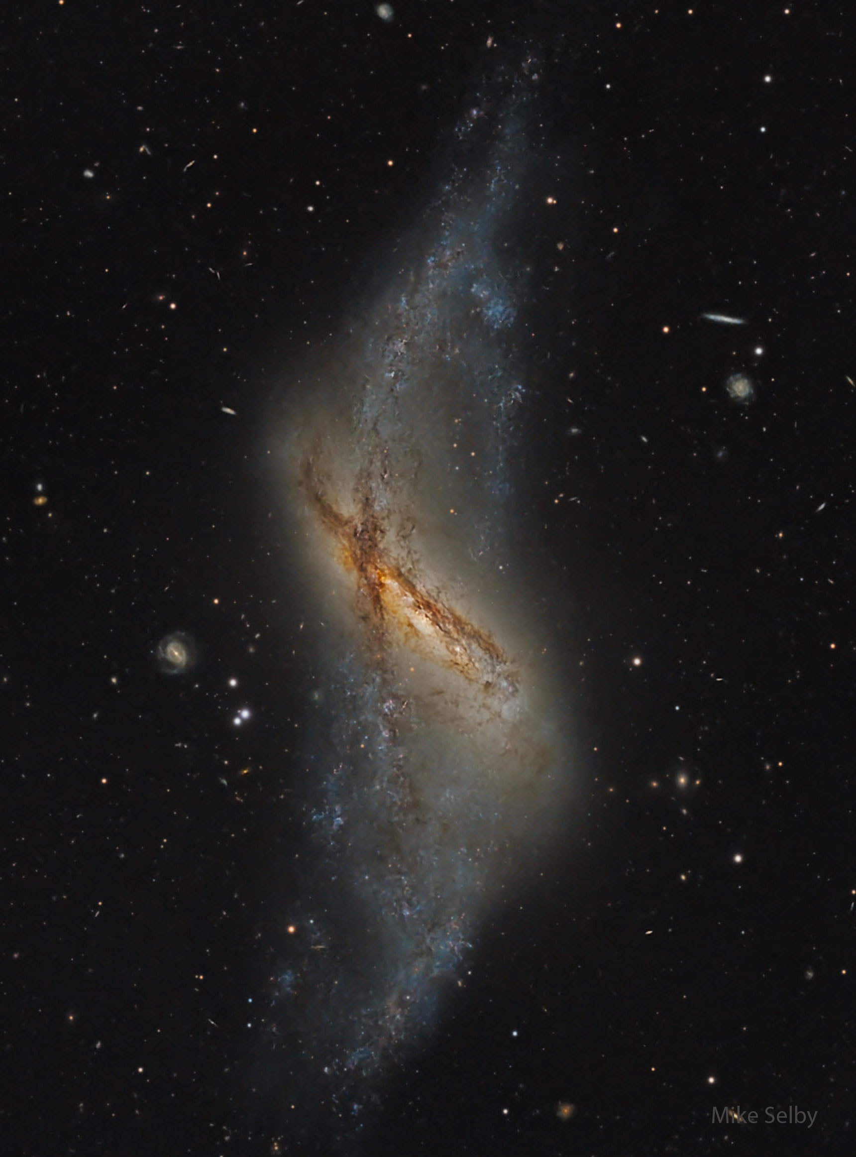 What kind of strange galaxy is this? This rare structure is known as a polar ring galaxy, and it seems to have two different rings of stars.  In this galaxy, NGC 660, one ring of bright stars, gas, and dark dust appears nearly vertical, while another similar but shorter ring runs diagonally from the upper left.  How polar ring galaxies obtain their striking appearance remains a topic of research, but a leading theory holds that it is usually the result of two galaxies with different central ring planes colliding.  NGC 660 spans about 50,000 light years and is located about 40 million light years away toward the constellation of the Fish (Pisces).  The featured image was captured recently from Observatorio El Sauce in Chile.