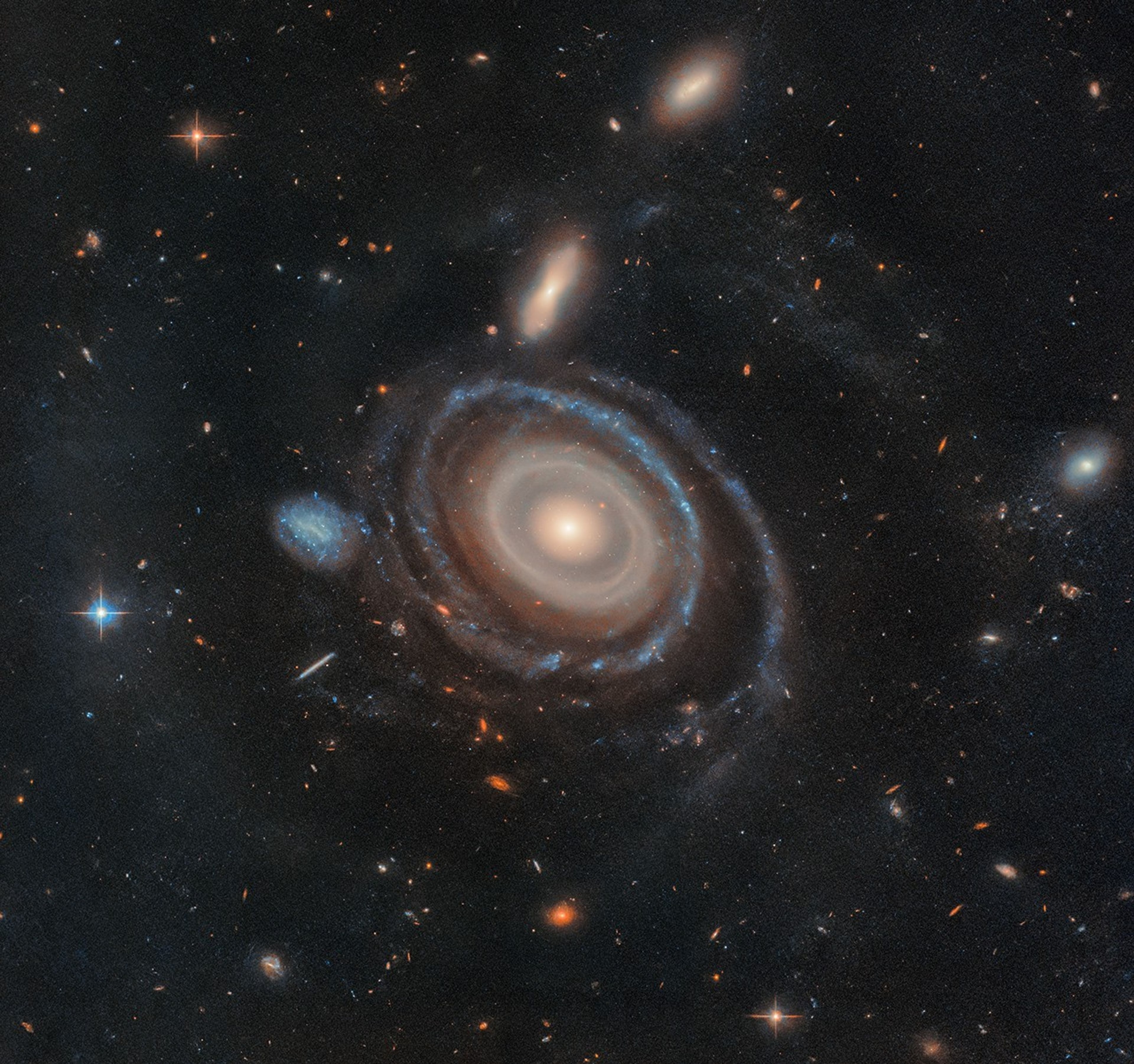 The giant galaxy cataloged as LEDA 1313424 is about two and a half times the size of our own Milky Way. Its remarkable appearance in this recently released Hubble Space Telescope image strongly suggests its nickname "The Bullseye Galaxy". Known as a collisional ring galaxy it has nine rings confirmed by telescopic observations, rippling from its center like waves from a pebble dropped into a pond. Of course, the pebble dropped into the Bullseye galaxy was a galaxy itself. Telescopic observations identify the blue dwarf galaxy at center-left as the likely collider, passing through the giant galaxy's center and forming concentric rings in the wake of their gravitational interaction. The Bullseye Galaxy lies some 567 million light-years away toward the constellation Pisces. At that distance, this stunning Hubble image would span about 530,000 light-years.