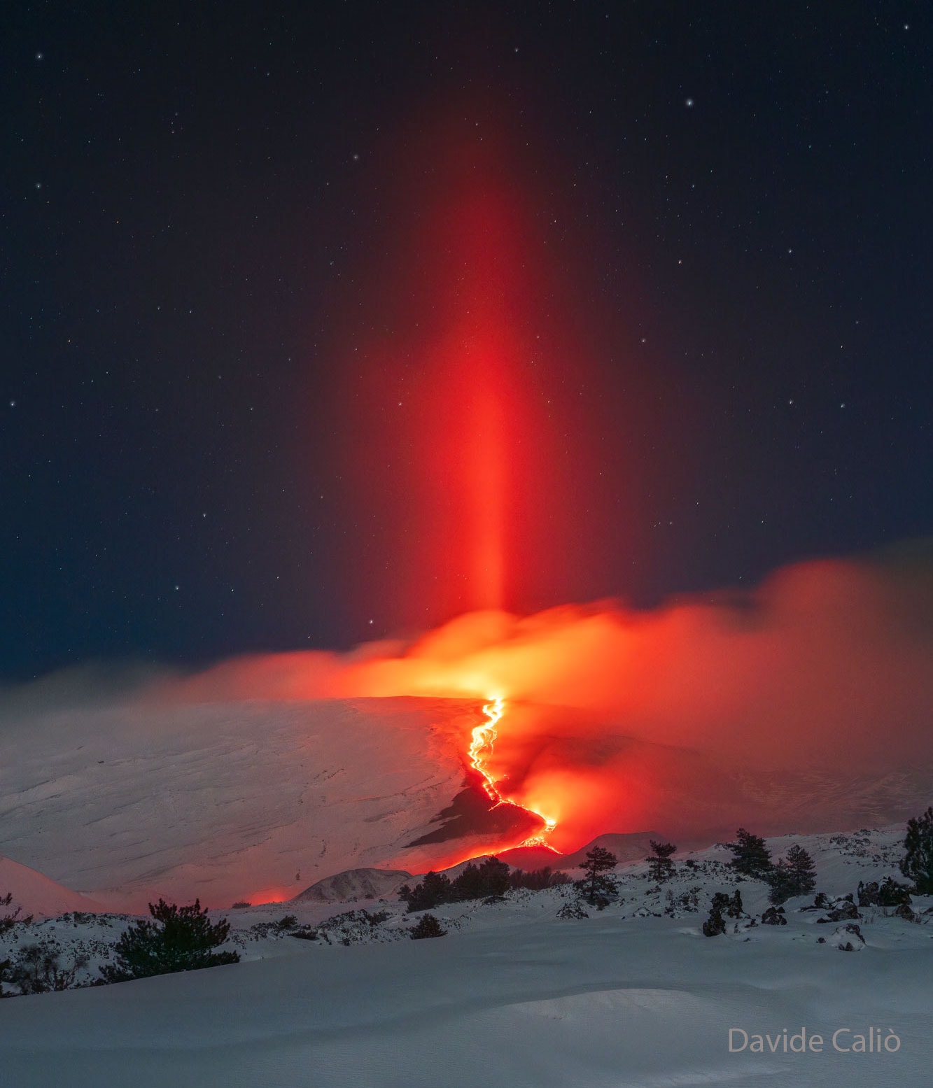 Can a lava flow extend into the sky? No, but light from the lava flow can. One effect is something quite unusual -- a volcanic light pillar. More typically, light pillars are caused by sunlight and so appear as a bright column that extends upward above a rising or setting Sun. Alternatively, other light pillars -- some quite colorful -- have been recorded above street and house lights. This light pillar, though, was illuminated by the red light emitted by the glowing magma of an erupting volcano. The volcano is Italy's Mount Etna, and the featured image was captured with a single shot during an early morning in mid-February. Freezing temperatures above the volcano's lava flow created ice-crystals either in the air above the volcano or in condensed water vapor expelled by Mount Etna. These ice crystals -- mostly flat toward the ground but fluttering -- then reflected away light from the volcano's caldera.